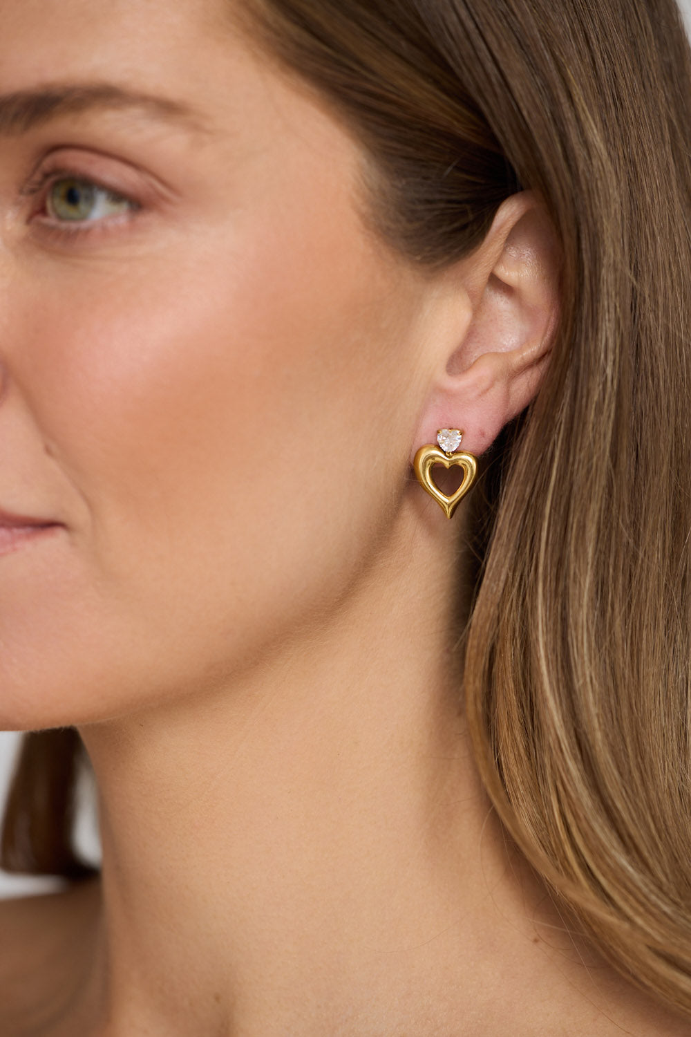 Model wearing Beloved Earrings in gold with a soft sculptural finish, model close-up view on neutral background