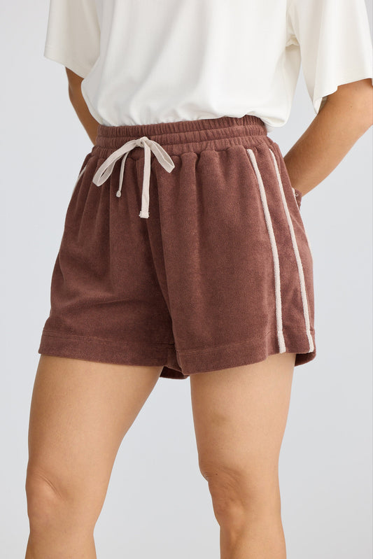 Brown shorts with a white drawstring and stripe on a plain background