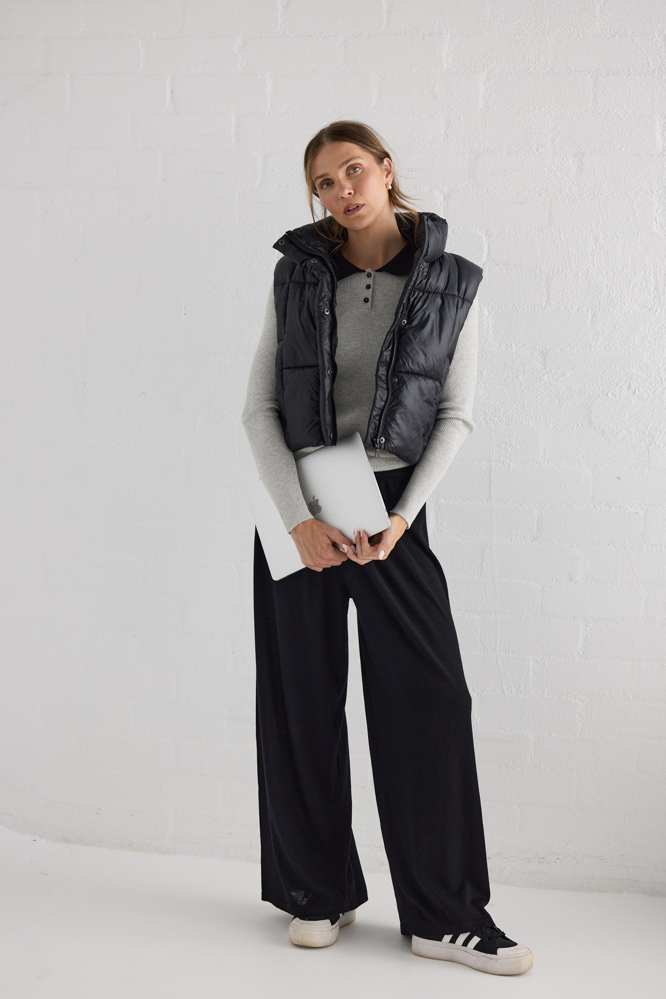 Campaign image of model wearing Linden Puffer Vest in black.
