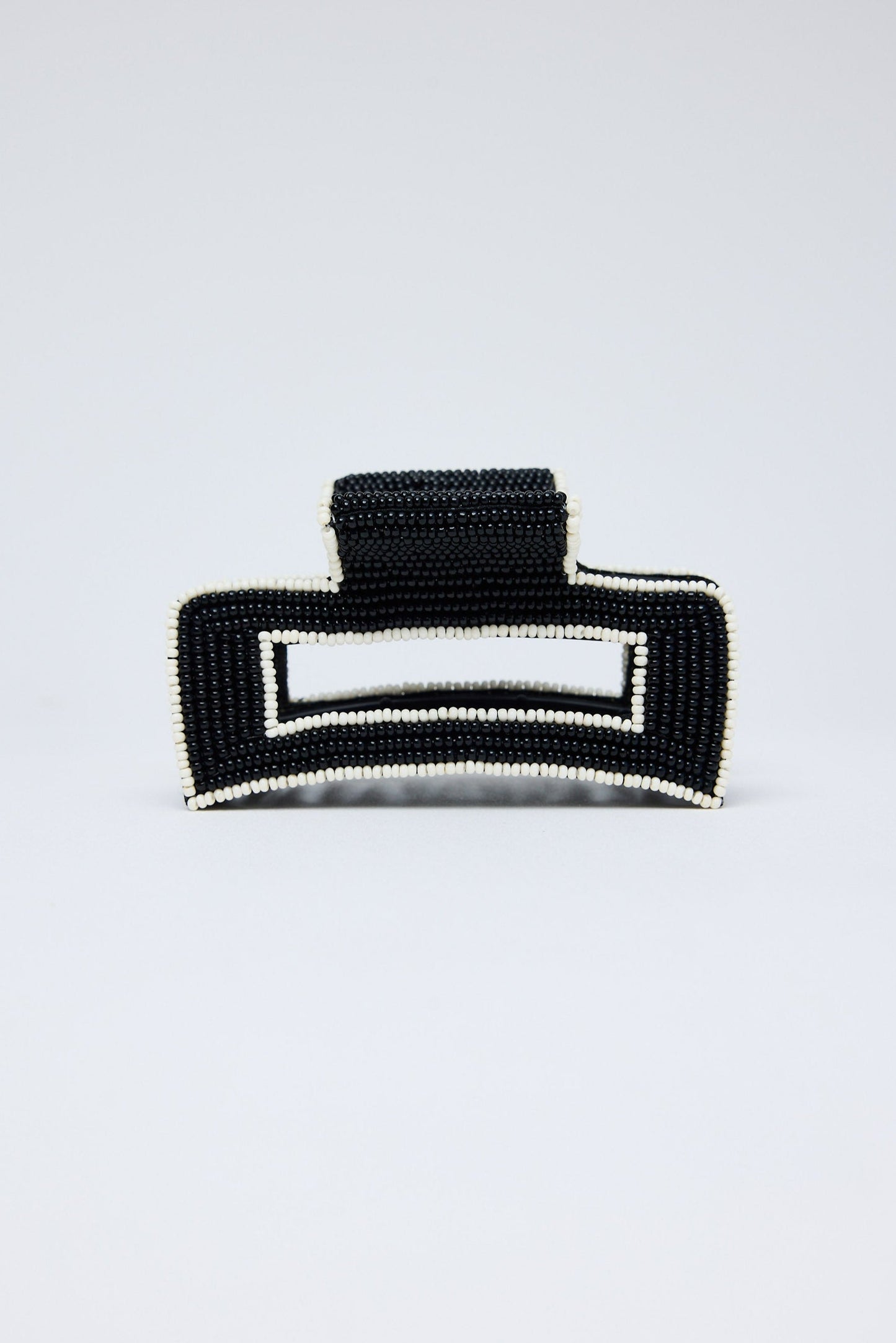 Black beaded clutch bag on a light gray background