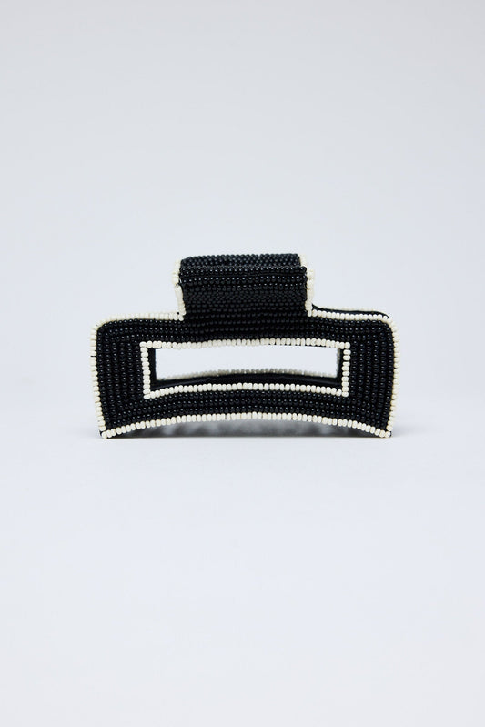 Black beaded clutch bag on a light gray background
