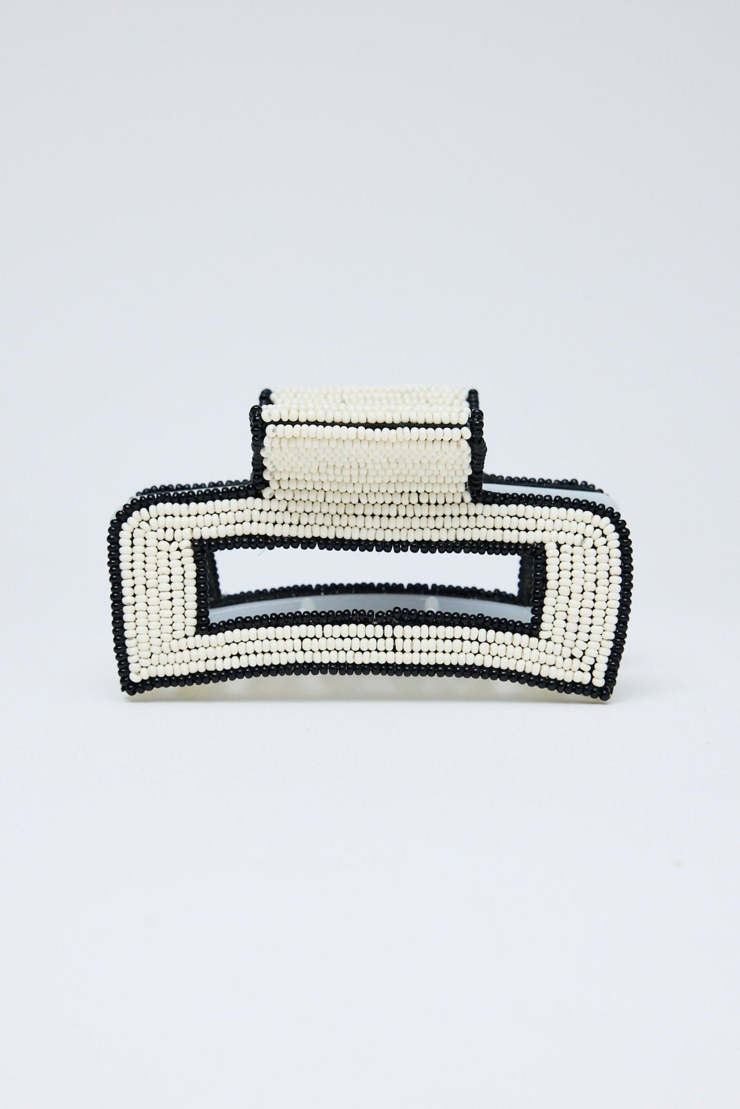 Black and white beaded hair clip on a light gray background