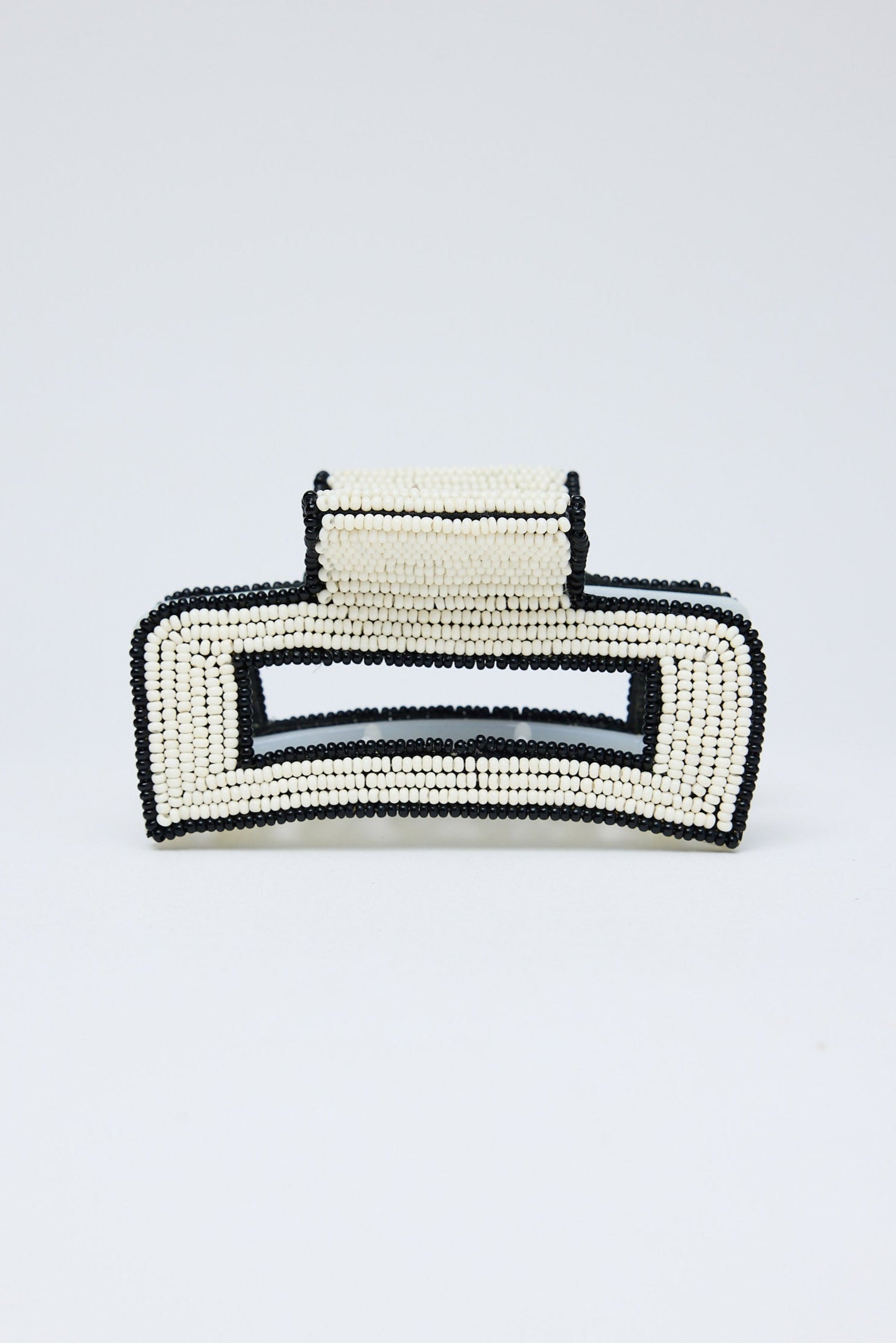 Black and white beaded hair clip on a light gray background