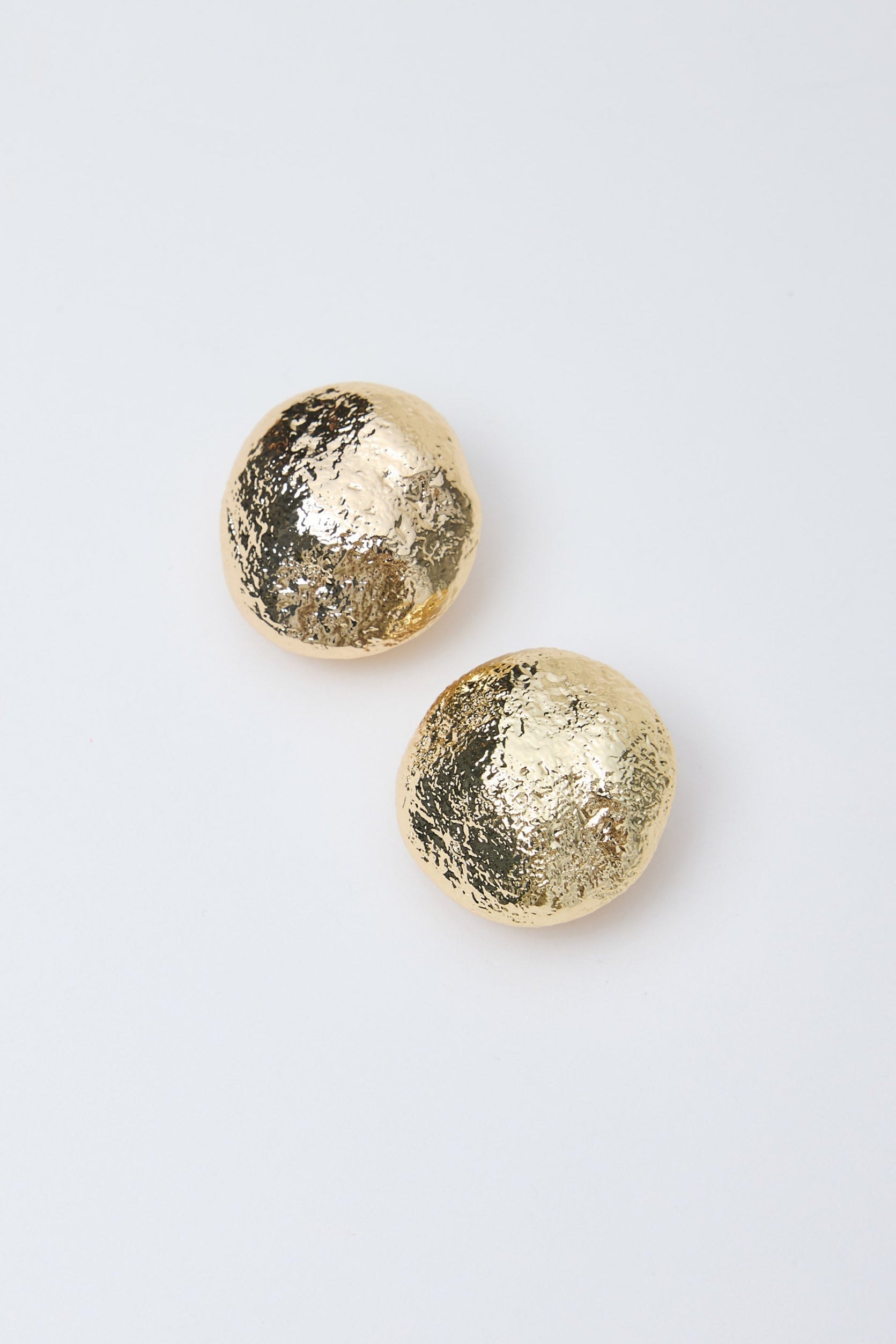 Pair of gold earrings on a light gray background