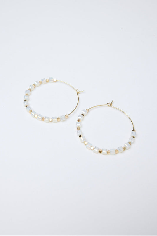 Pair of hoop earrings with pearl-like beads on a white background