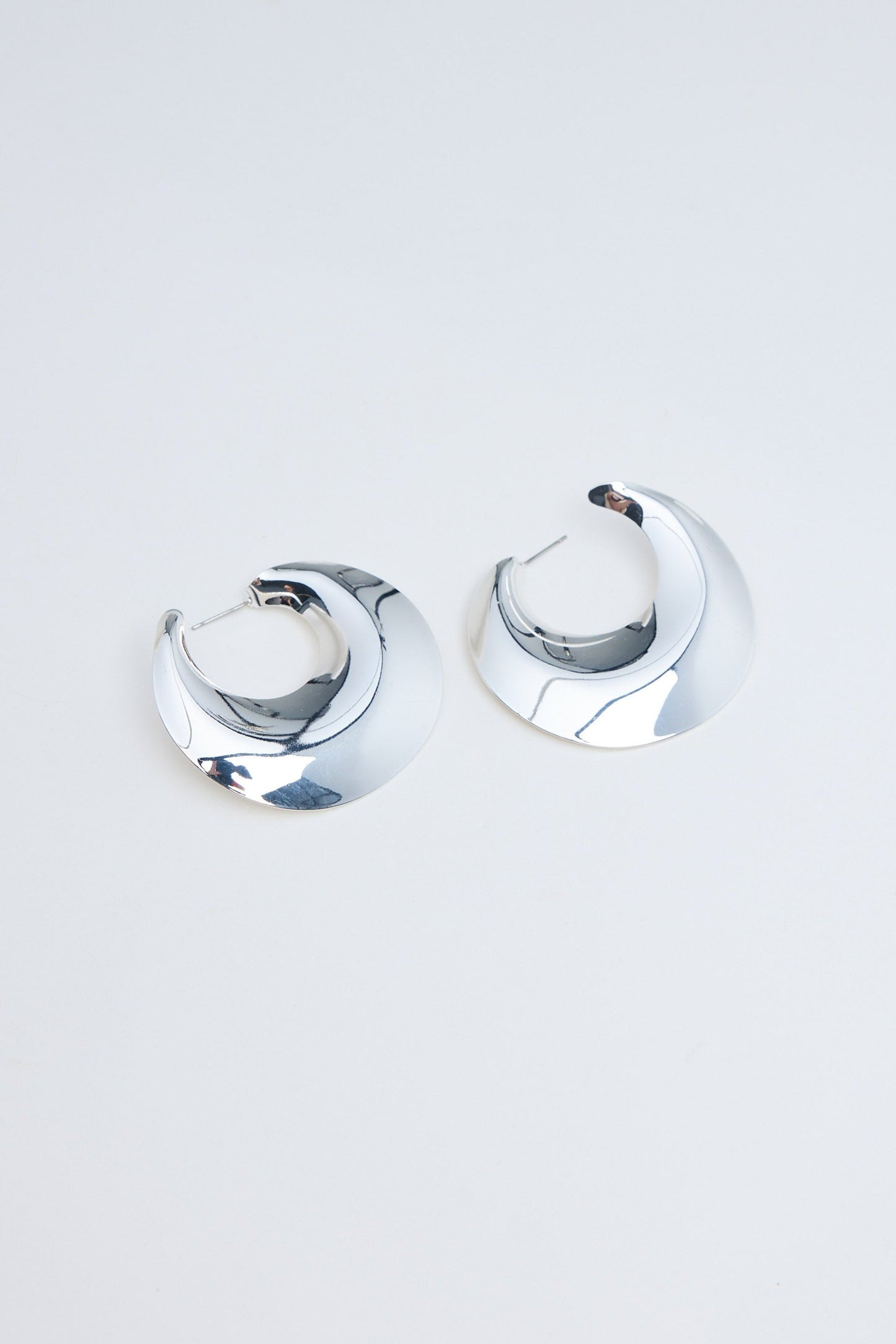 Pair of silver hoop earrings on a light gray background