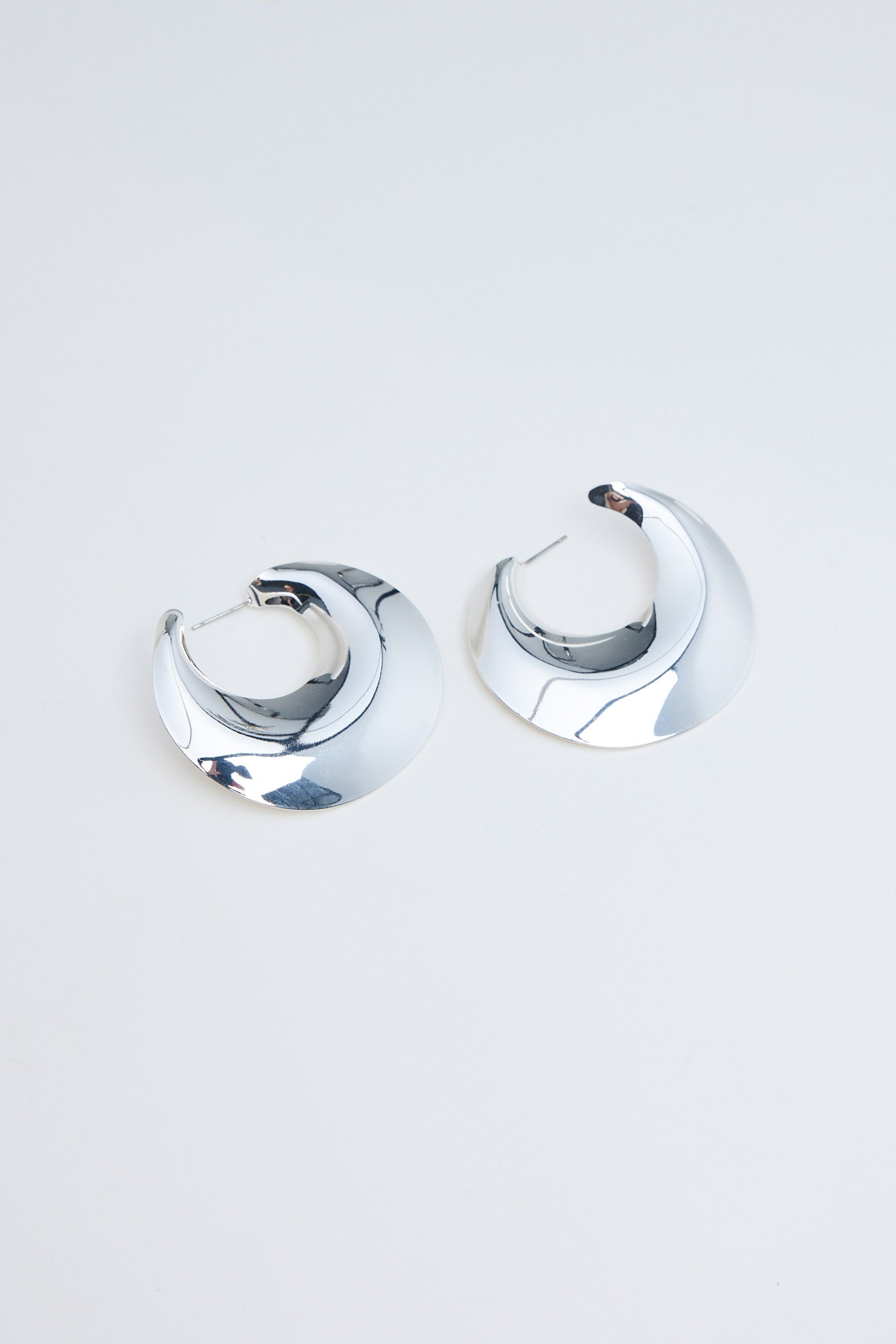 Pair of silver hoop earrings on a light gray background