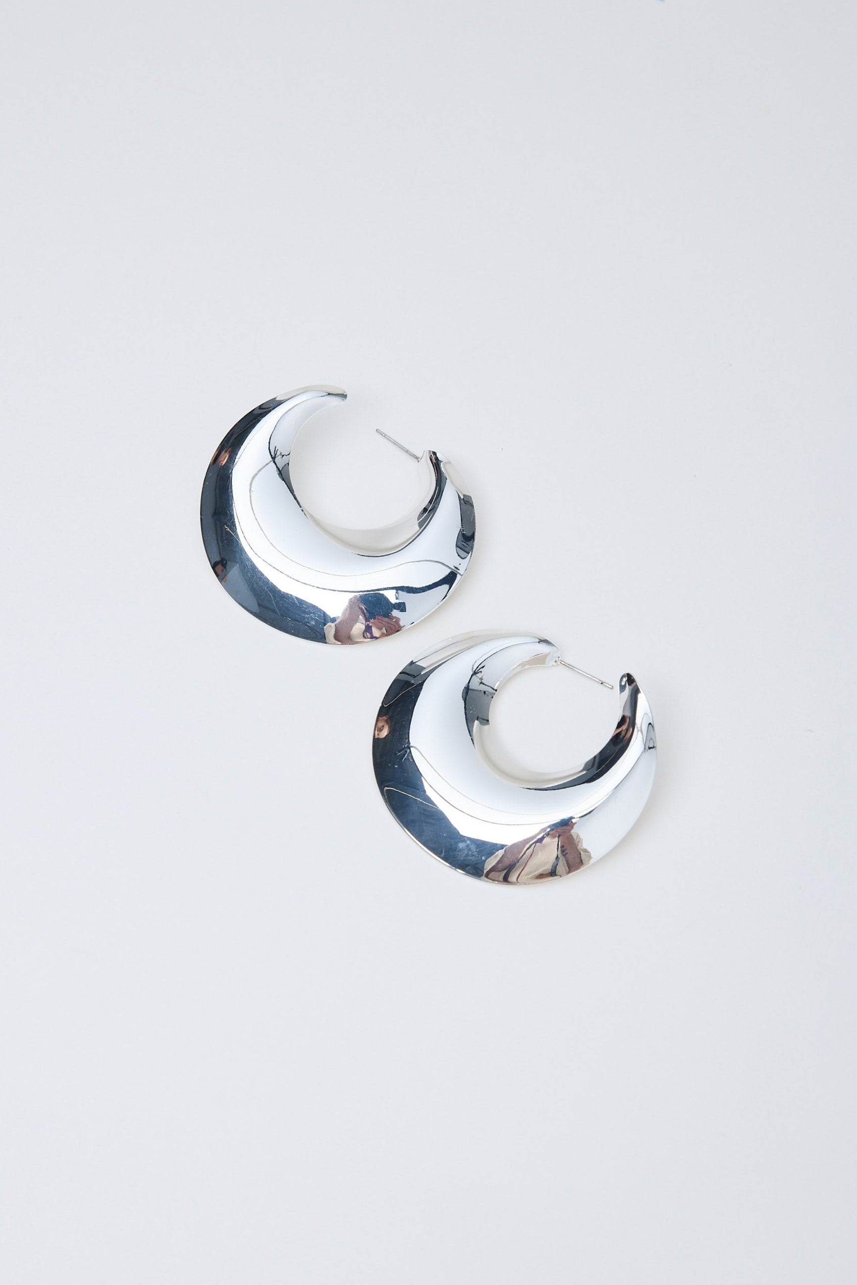 Pair of silver hoop earrings on a light gray background