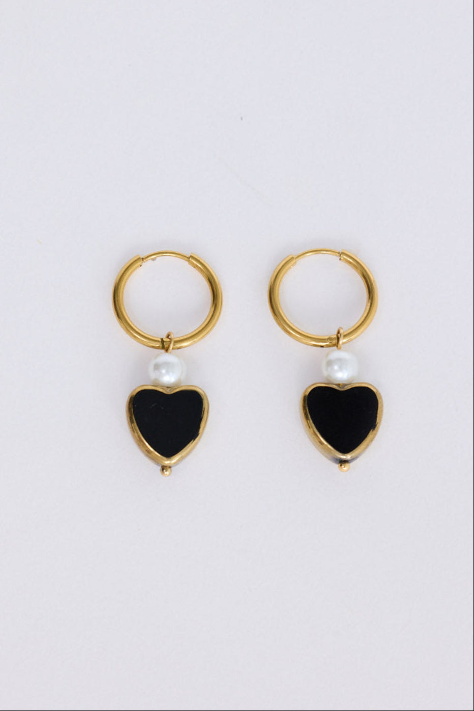 Mimi Earrings in black with bold heart charm detail, angled view on white background