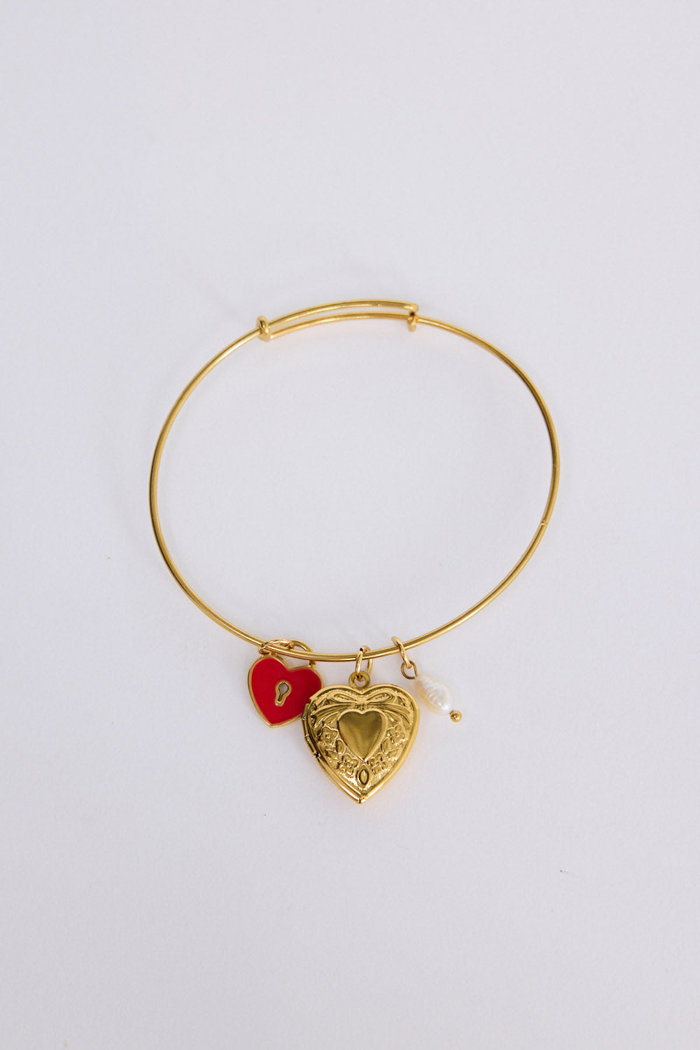 Hearty Bracelet in gold with multiple charm detailing, front view on white background