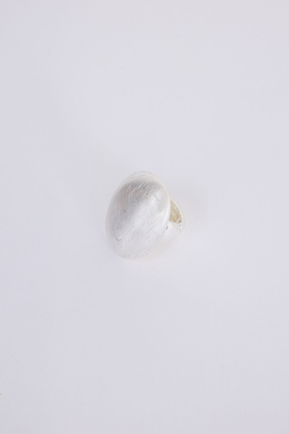 Nola Ring in silver with smooth domed face and brushed texture finish, front view on white background
