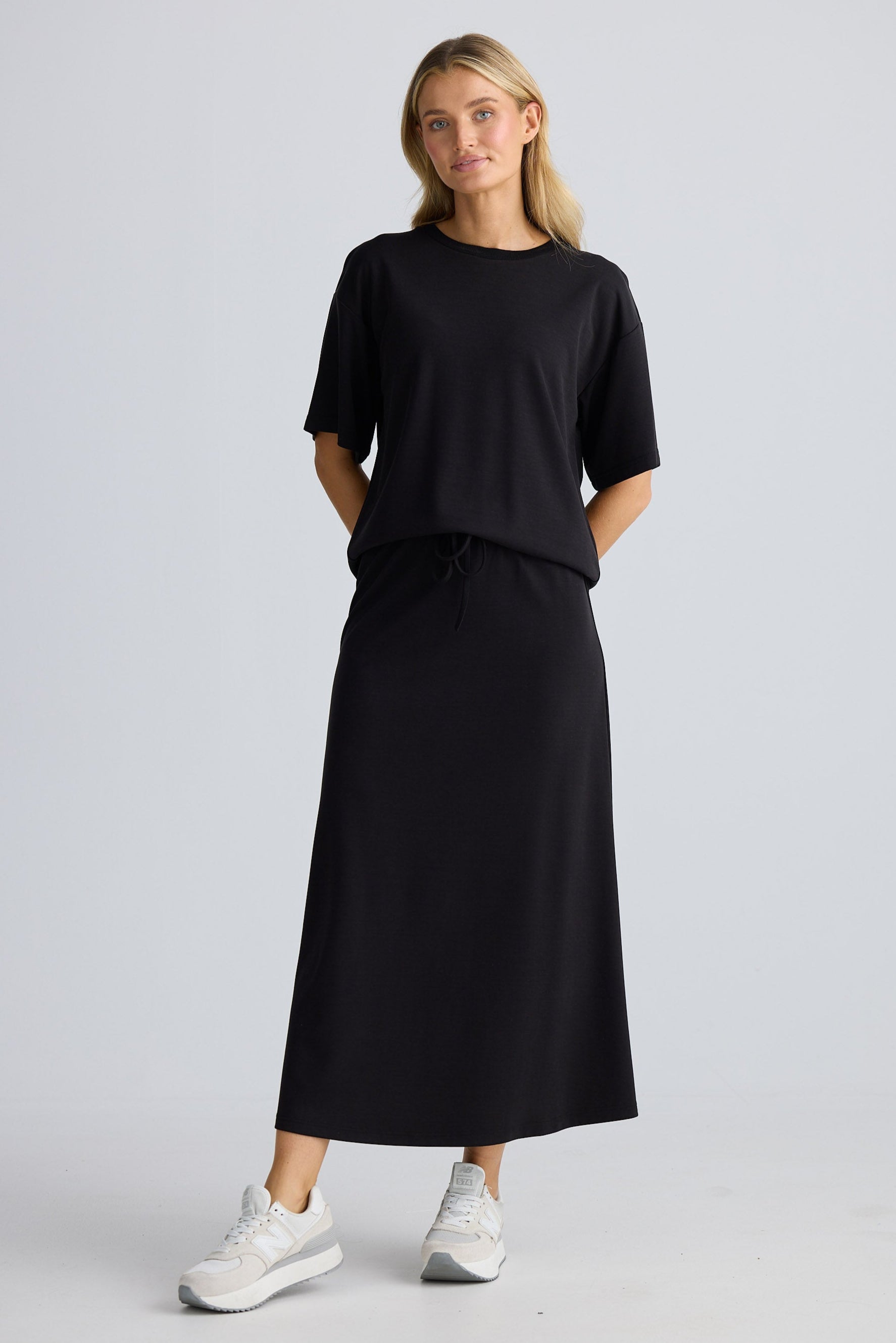 Woman wearing a black outfit with a plain background