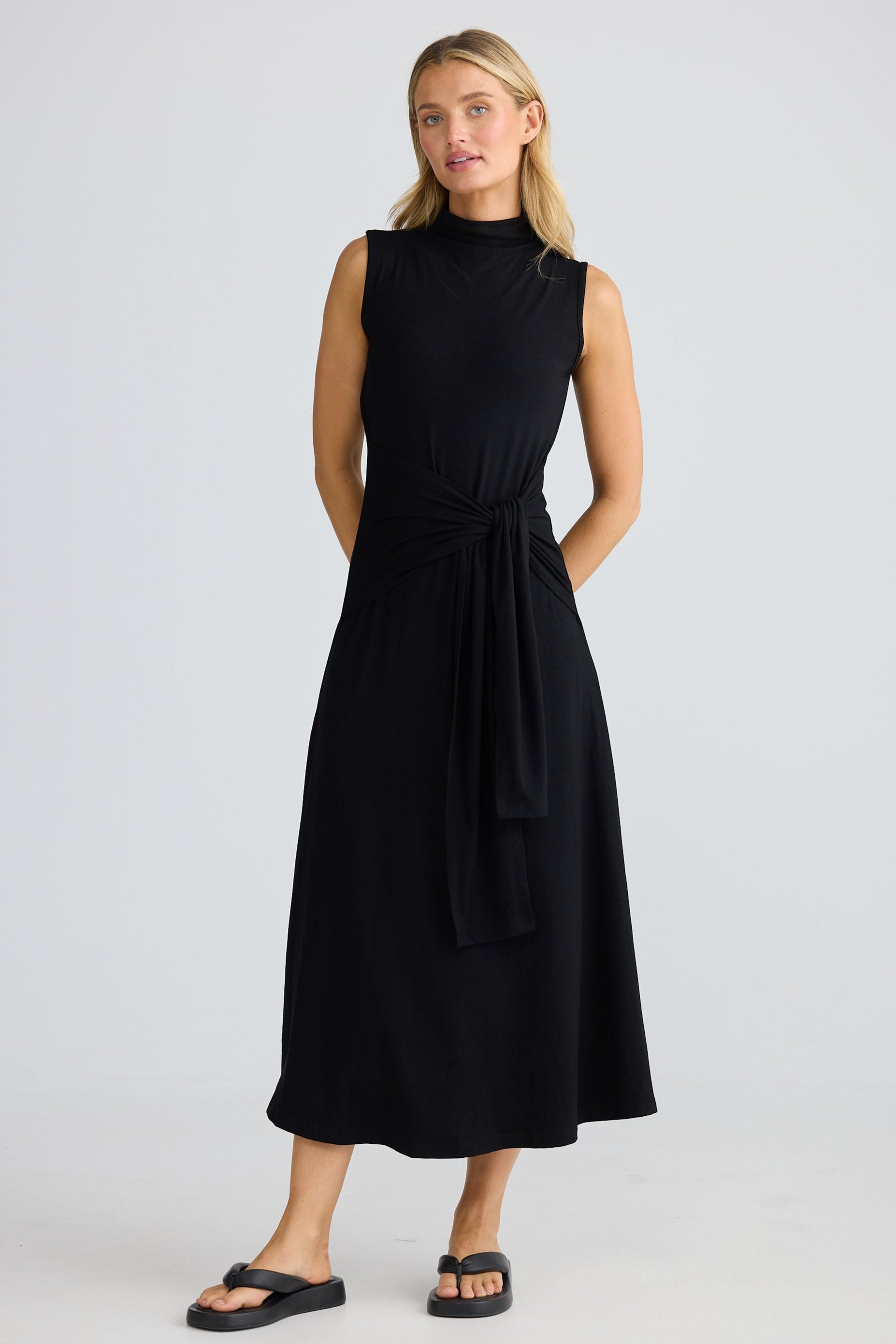 Woman wearing a black sleeveless dress on a white background