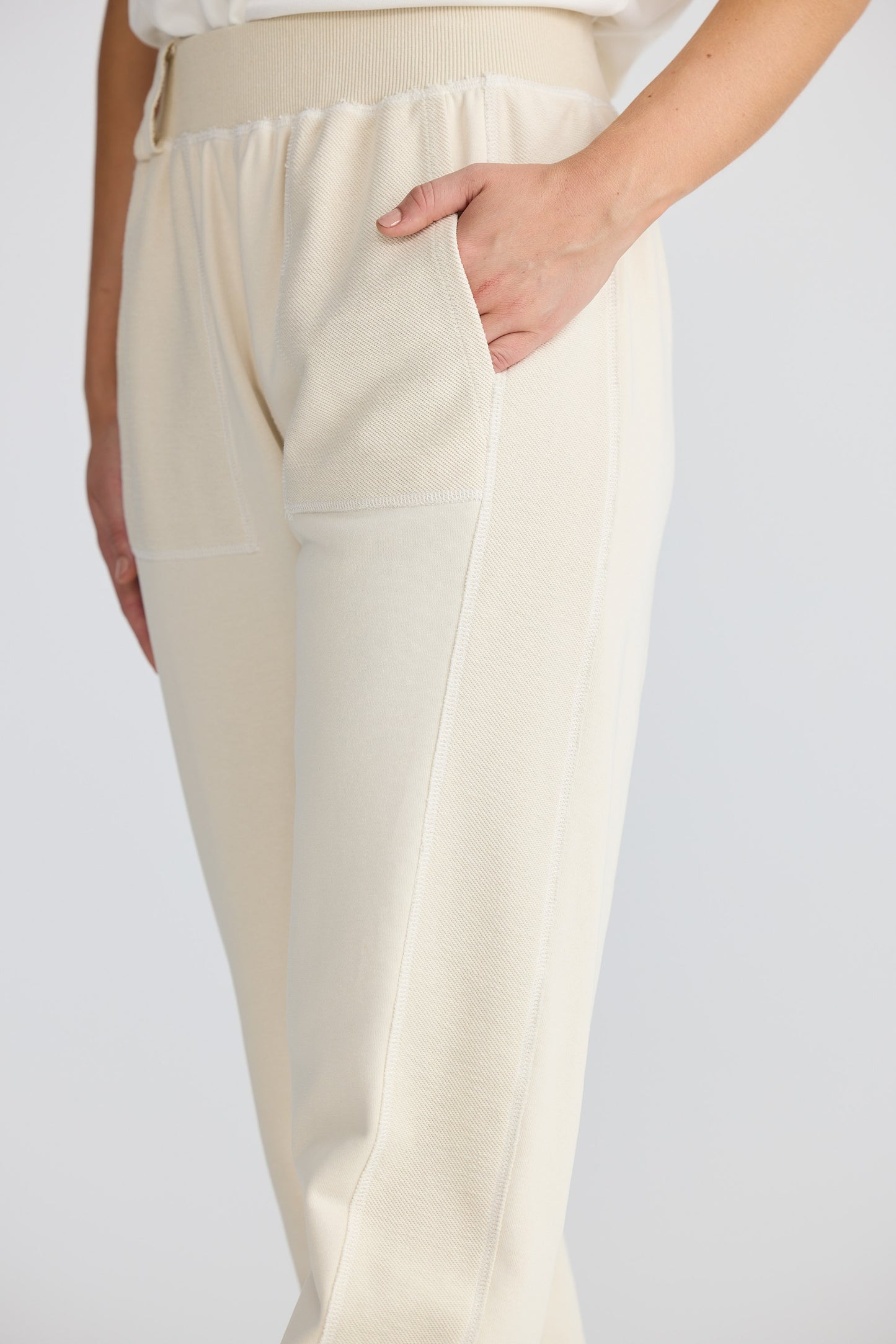 Beige pants worn by a person on a plain background