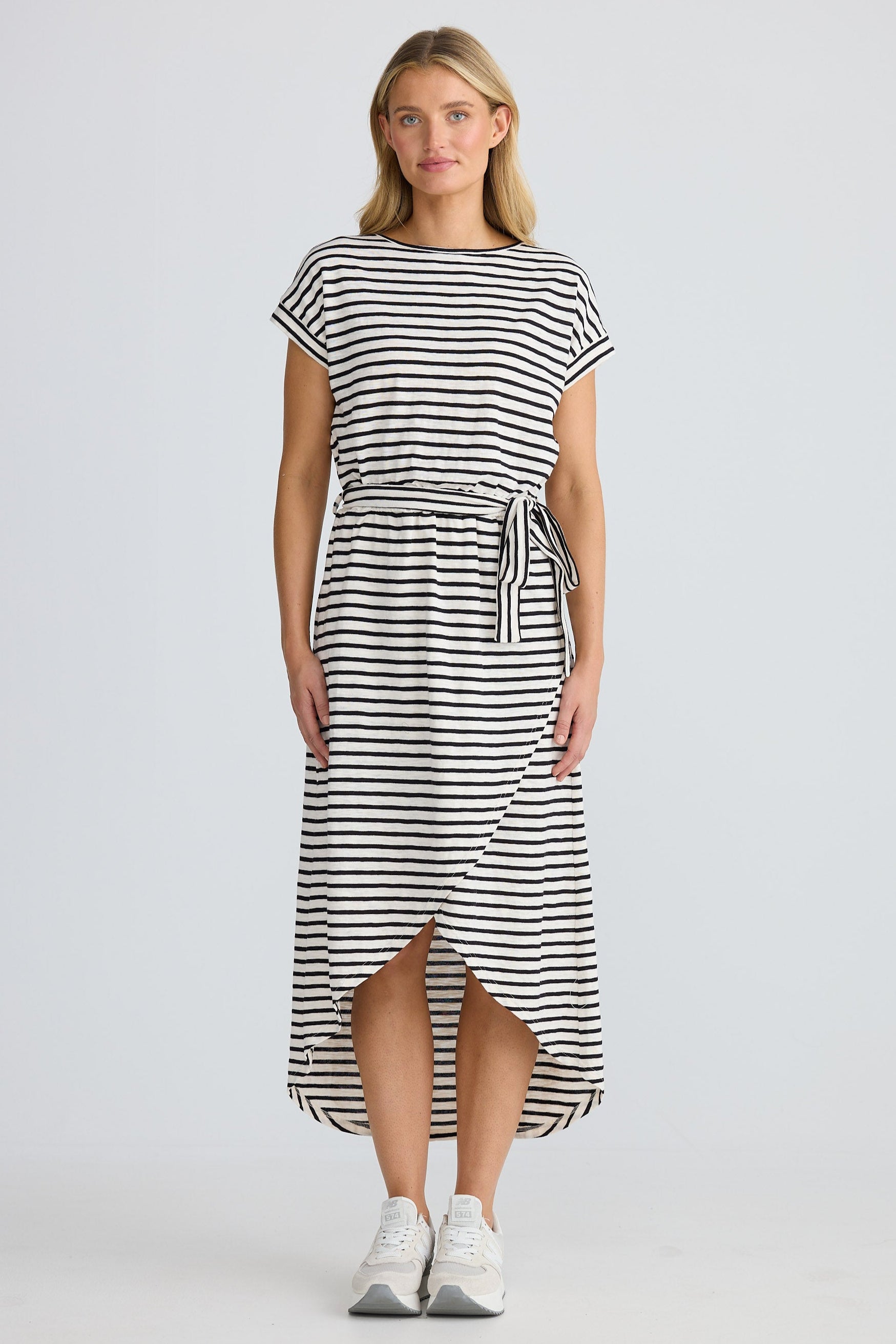 Woman wearing a black and white striped dress on a plain background