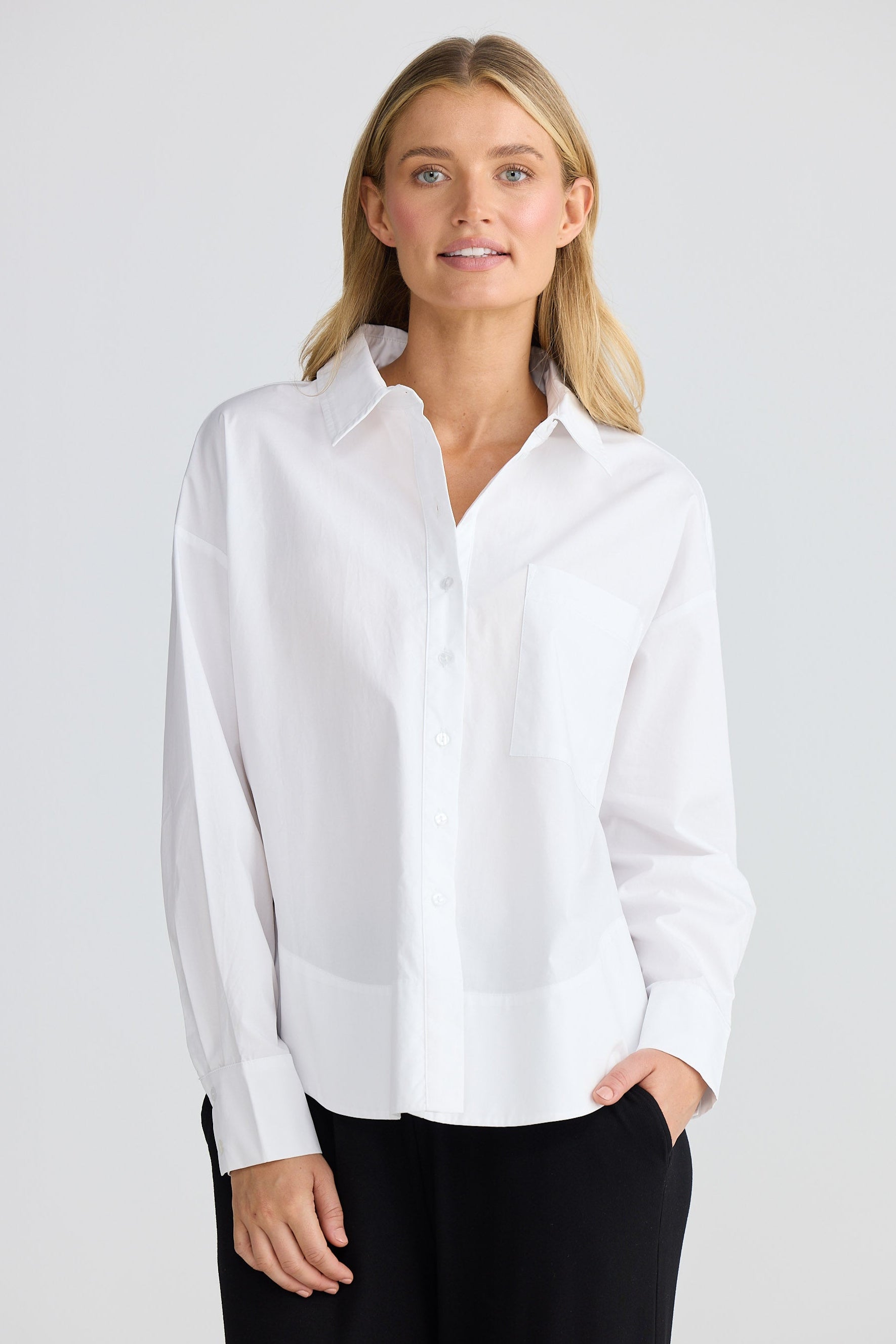Woman wearing a white shirt against a plain background