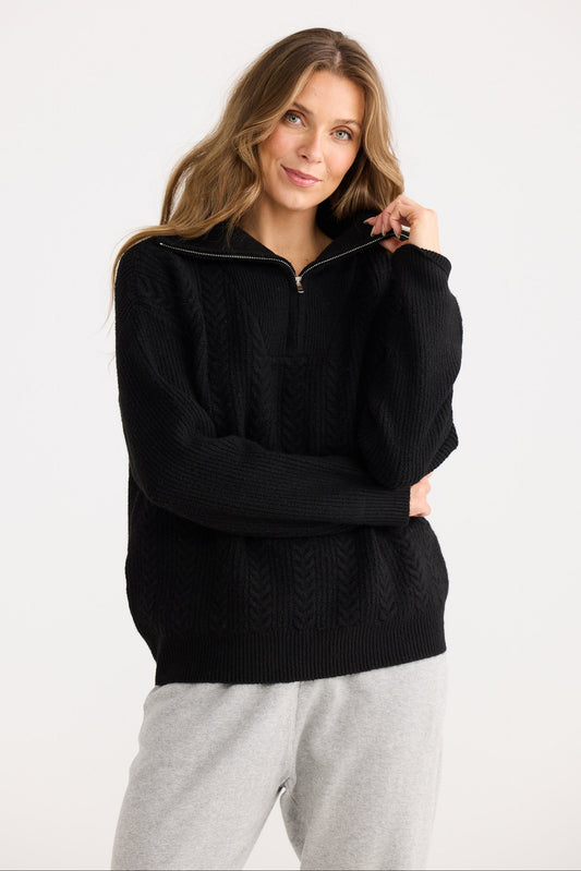 Woman wearing a black sweater with a zipper on a white background