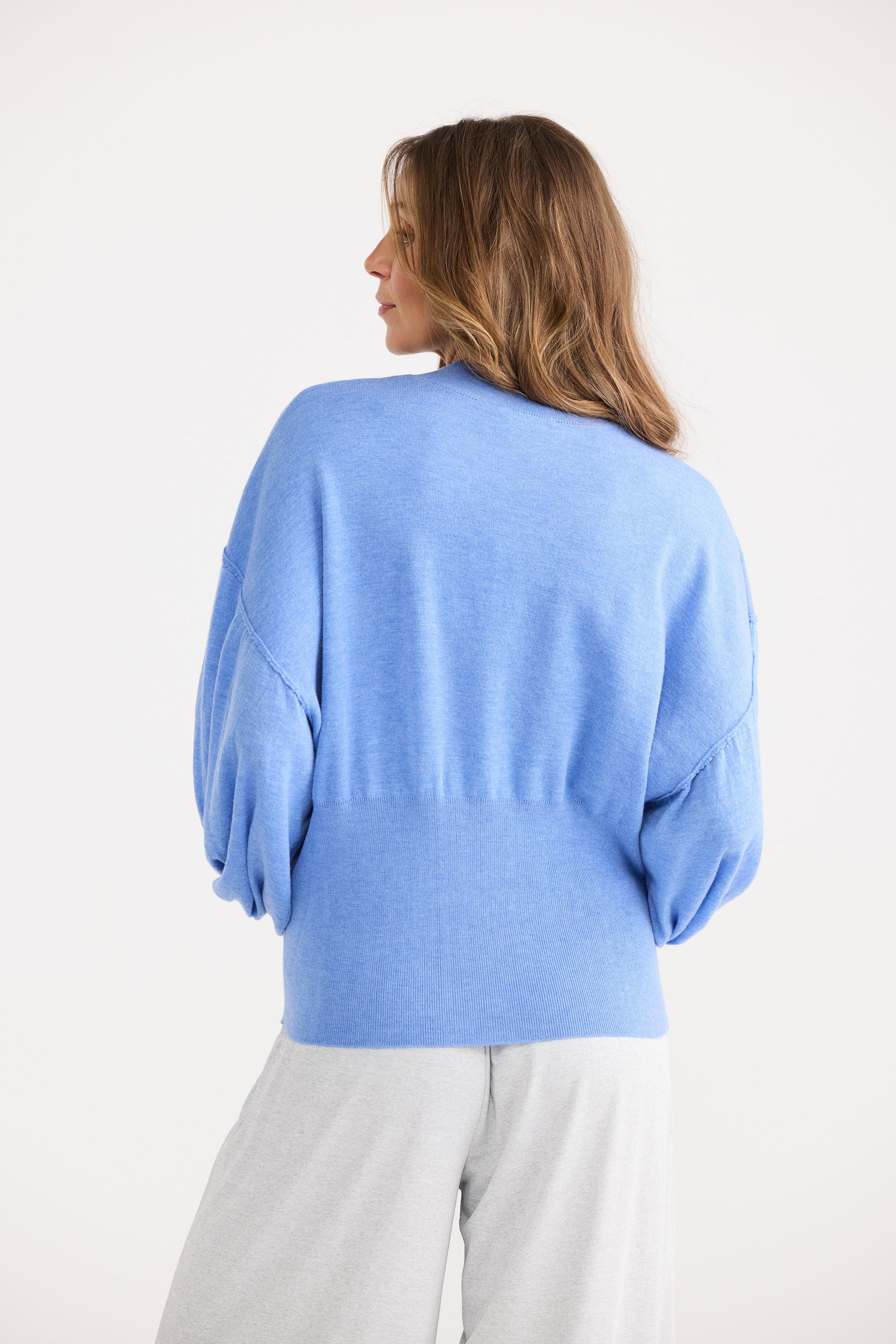 Woman wearing a light blue sweater on a white background