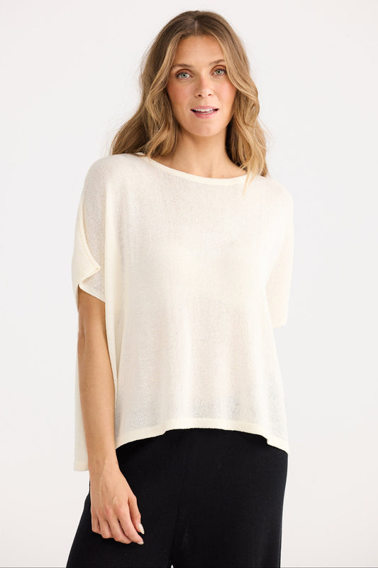 Woman wearing a white blouse and black pants on a white background