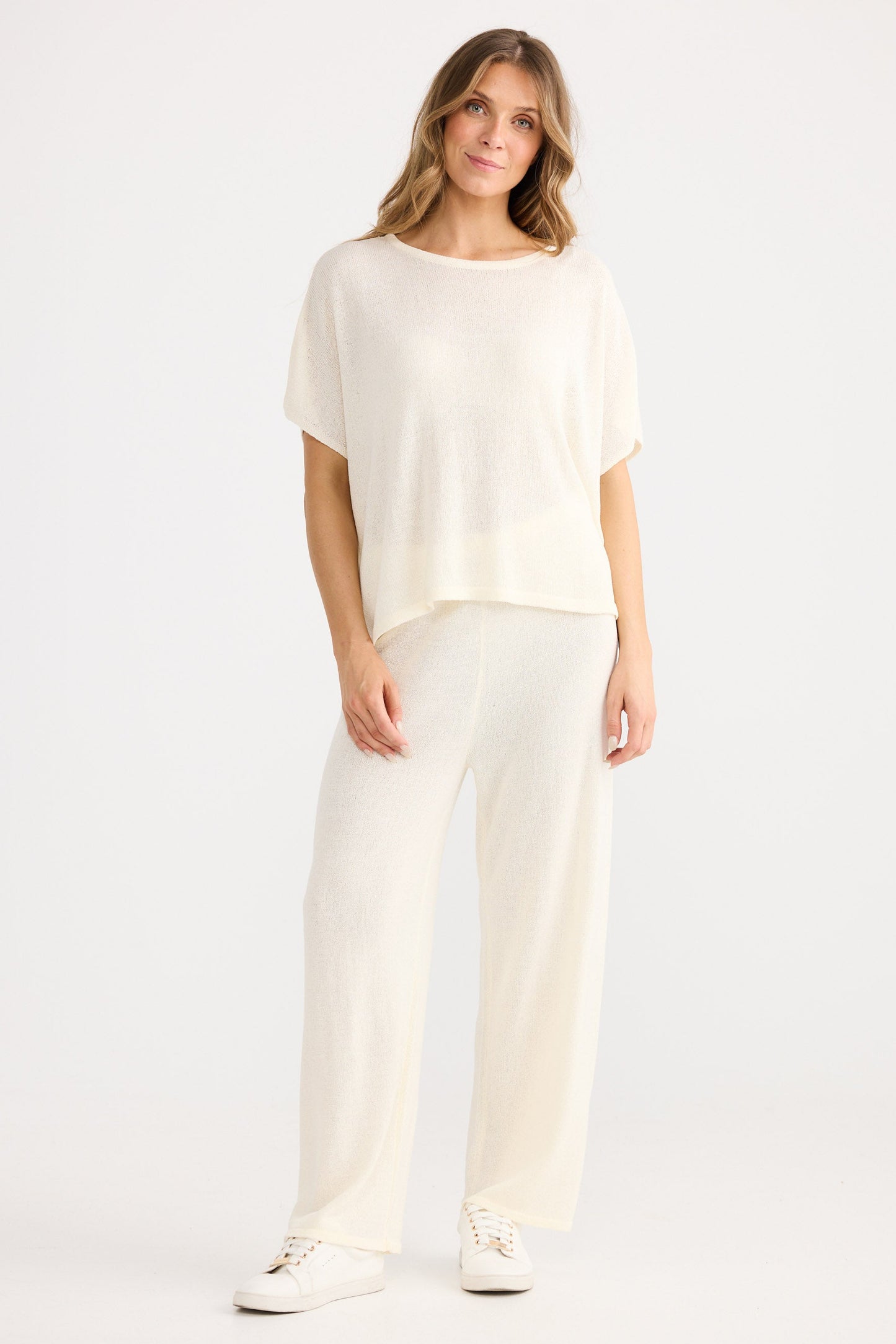 Woman wearing a white outfit on a plain background