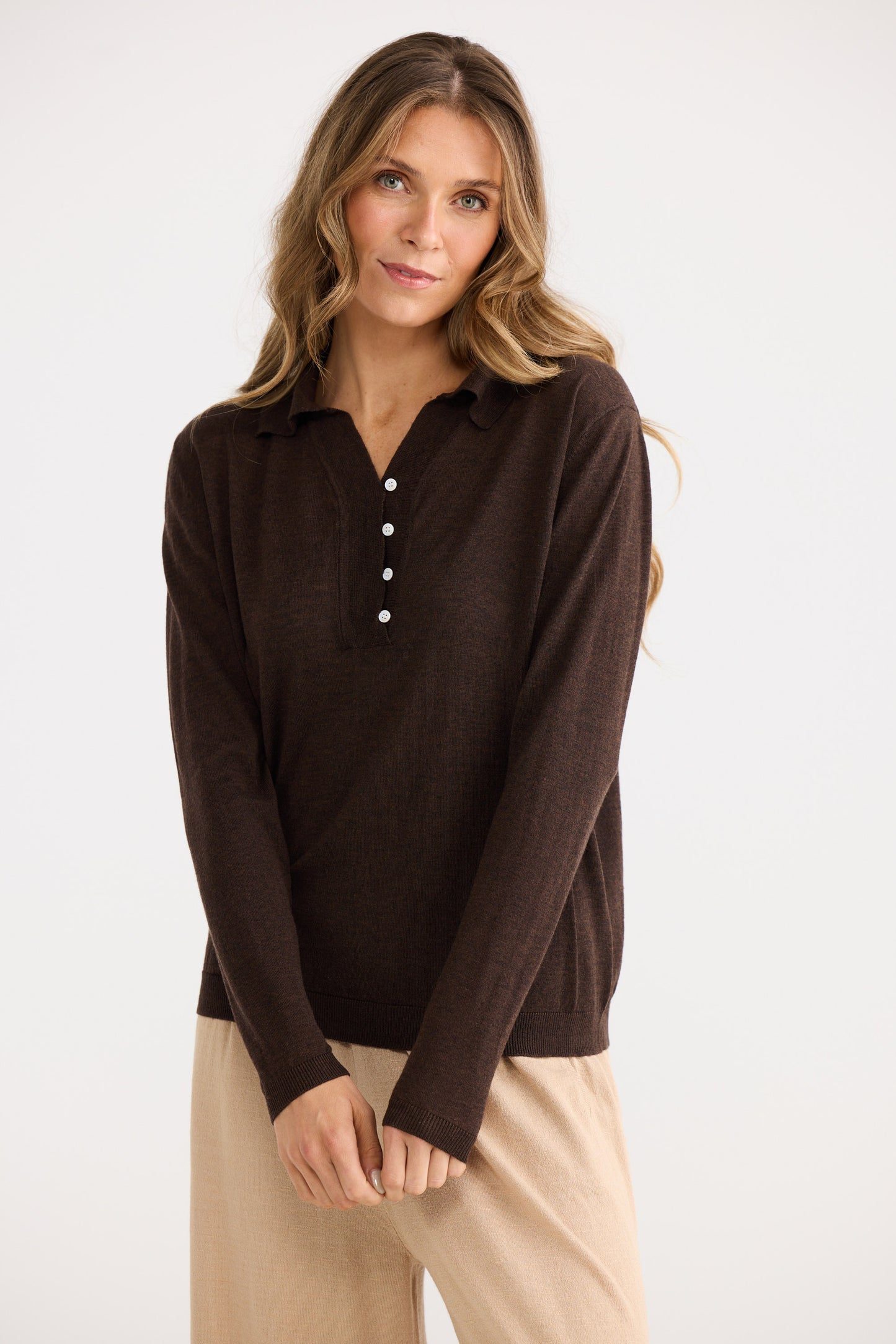Woman wearing a brown long-sleeve shirt with a white background