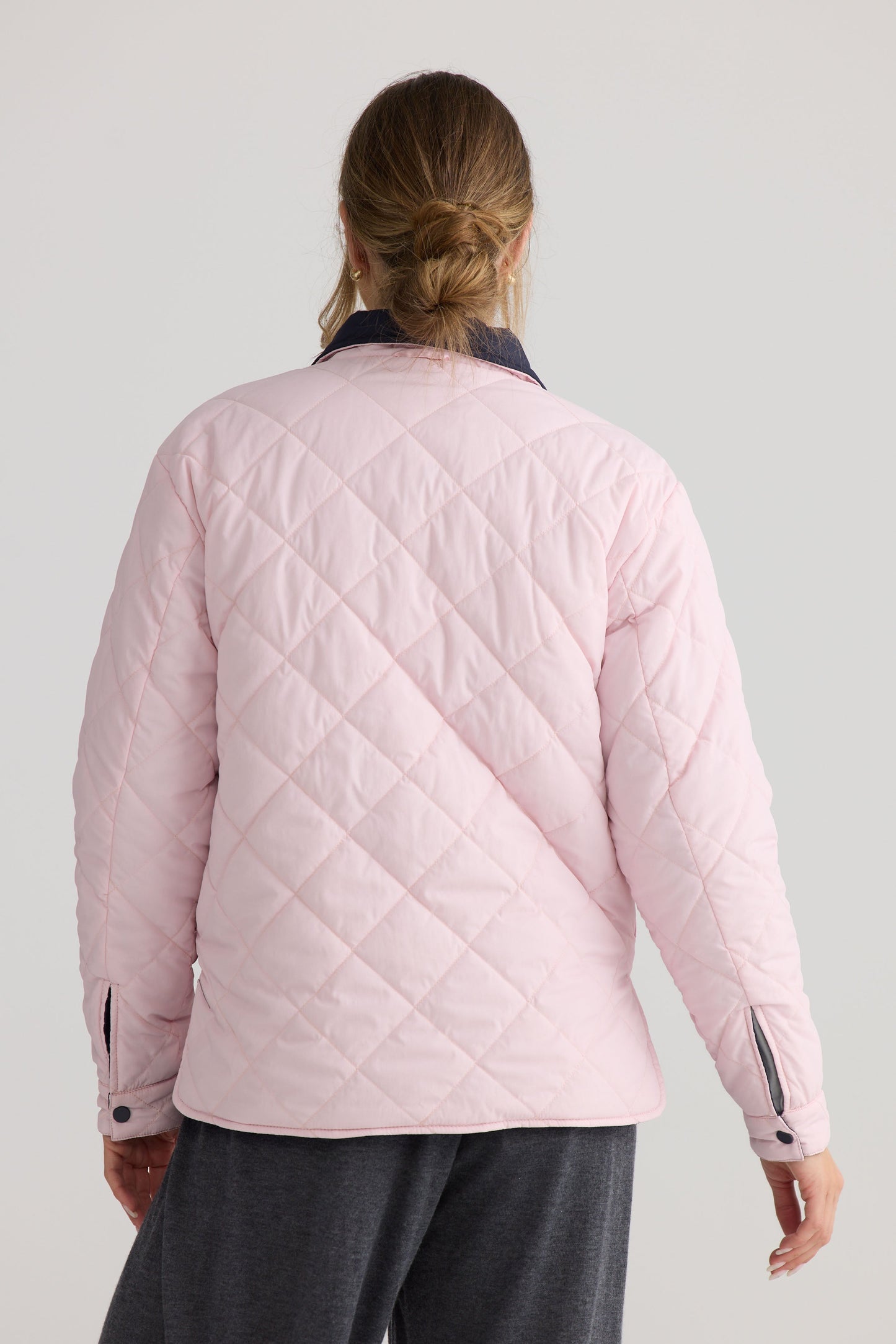 Model wearing Ellis Puffer in navy with pink, showing puffer quilting.