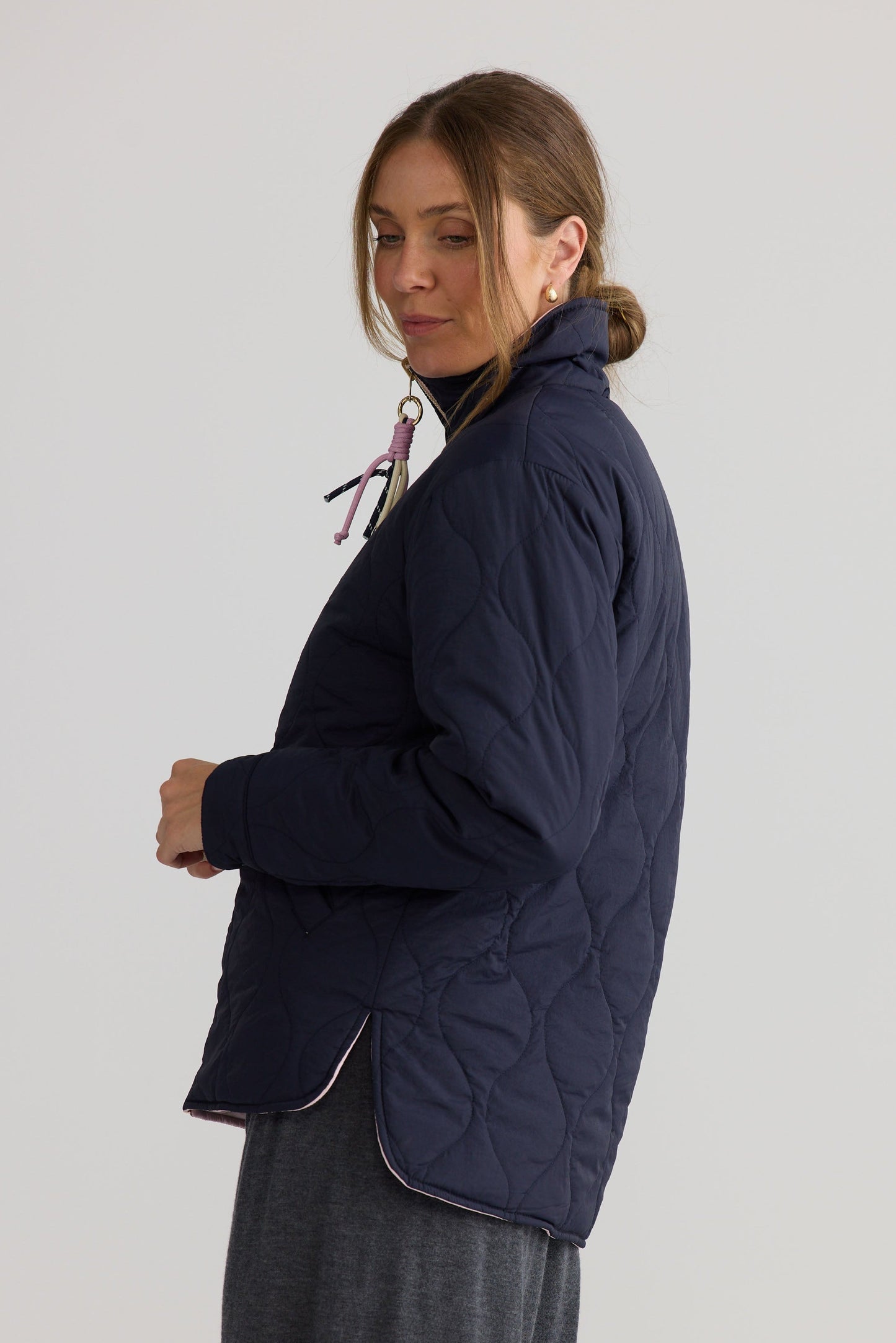 Ellis Puffer in navy with pink, styled with a relaxed outfit.