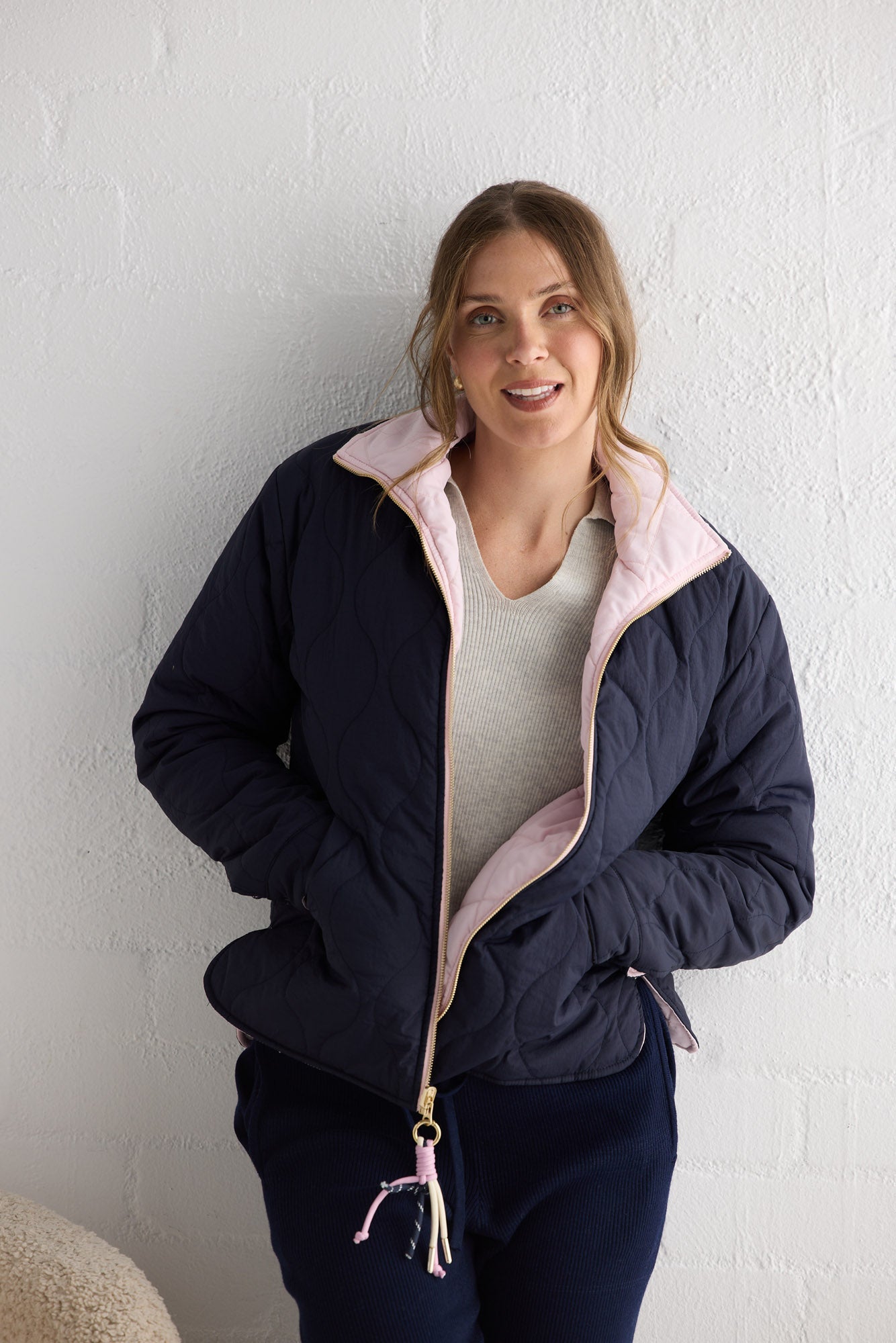 Campaign image of model wearing Ellis Puffer in navy with pink.