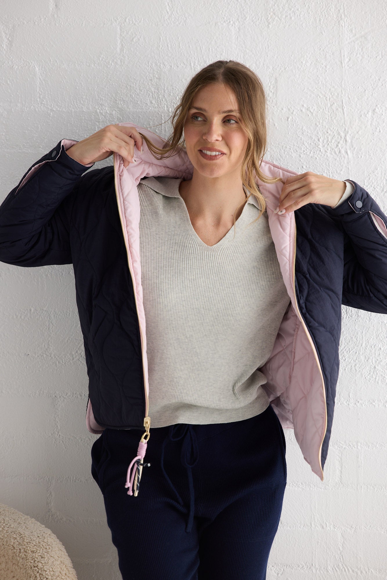 Campaign image of model wearing Ellis Puffer in navy with pink.