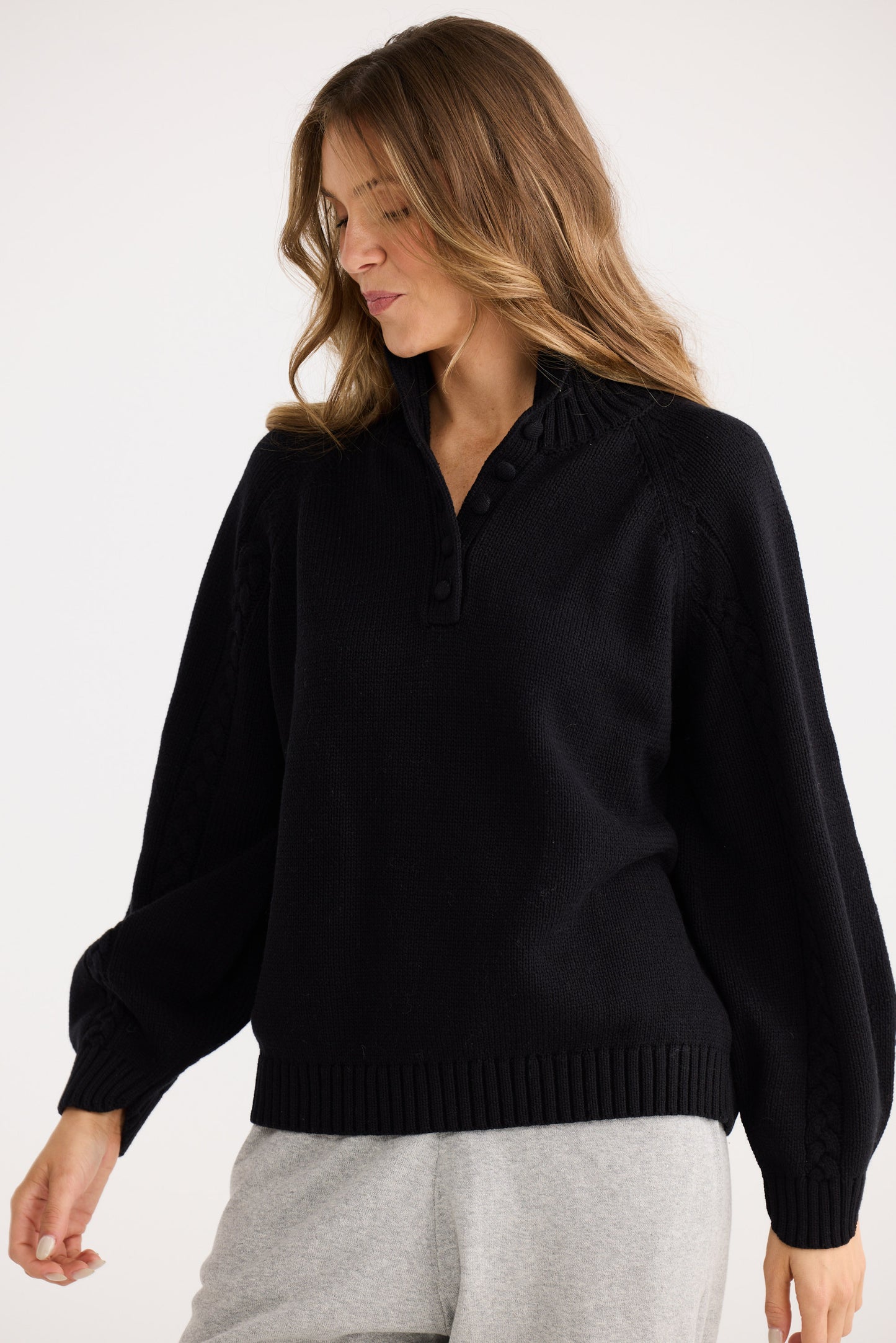 Woman wearing a black sweater against a white background