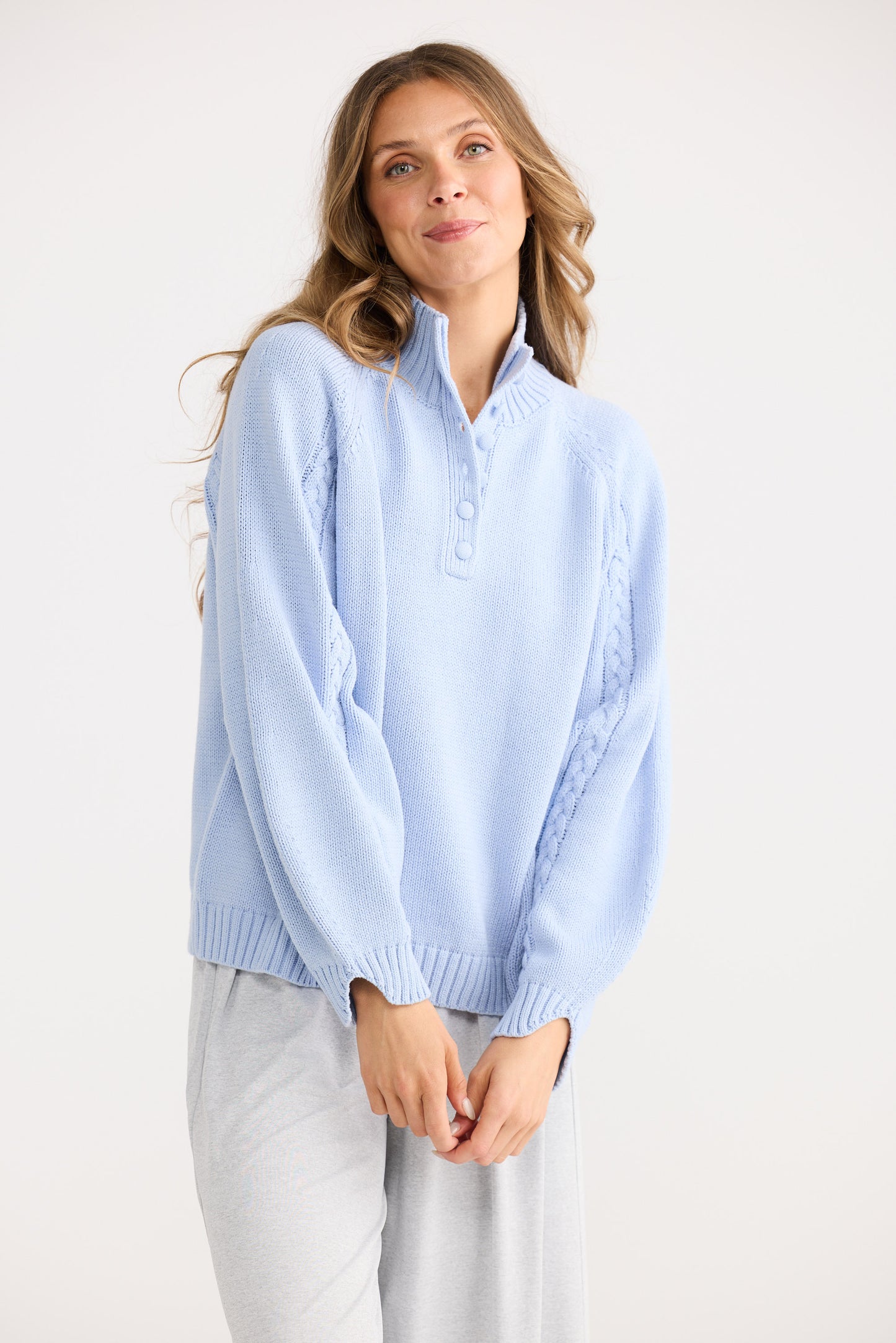 Woman wearing a light blue sweater against a white background