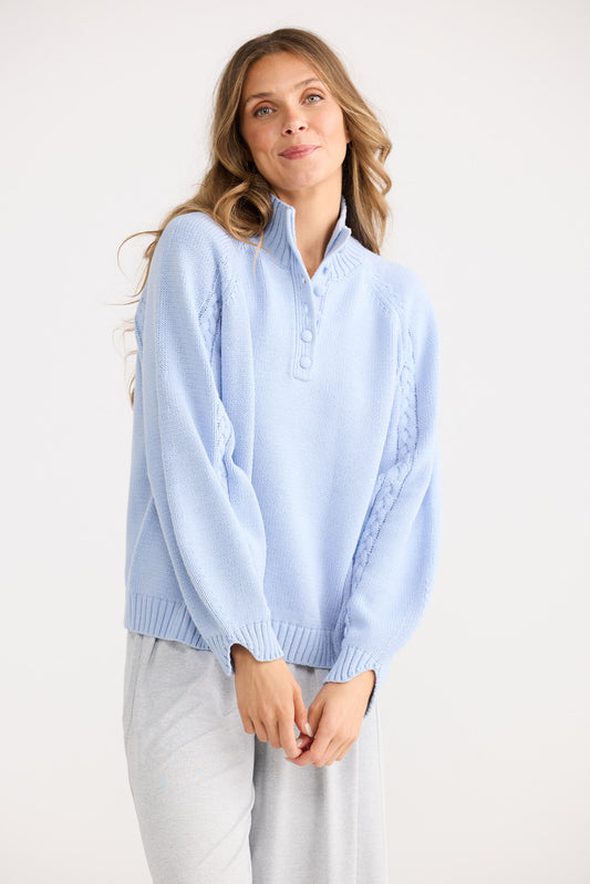 Woman wearing a light blue sweater against a white background