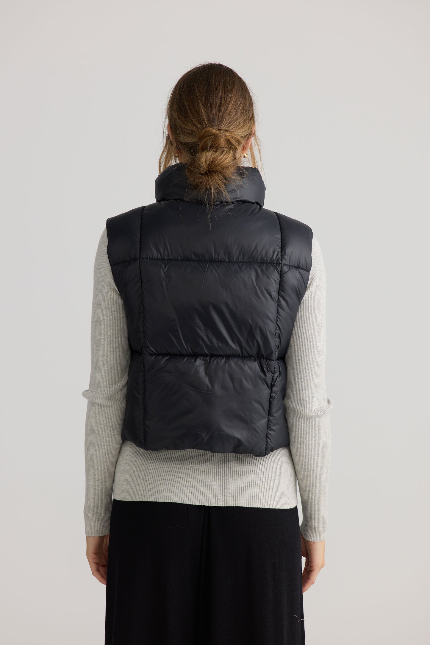 Model wearing Linden Puffer Vest in black.