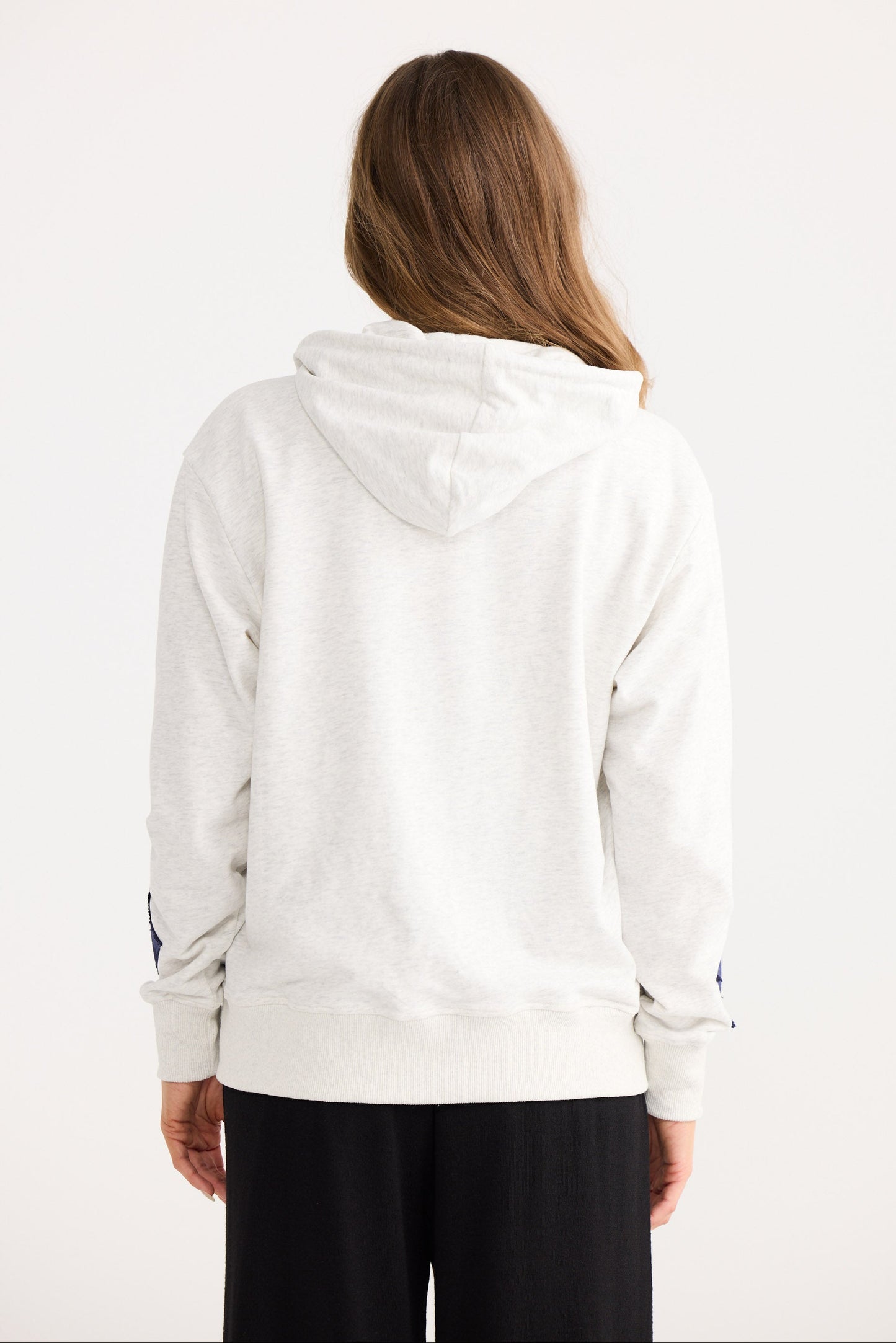 Person wearing a light gray hoodie with a white background