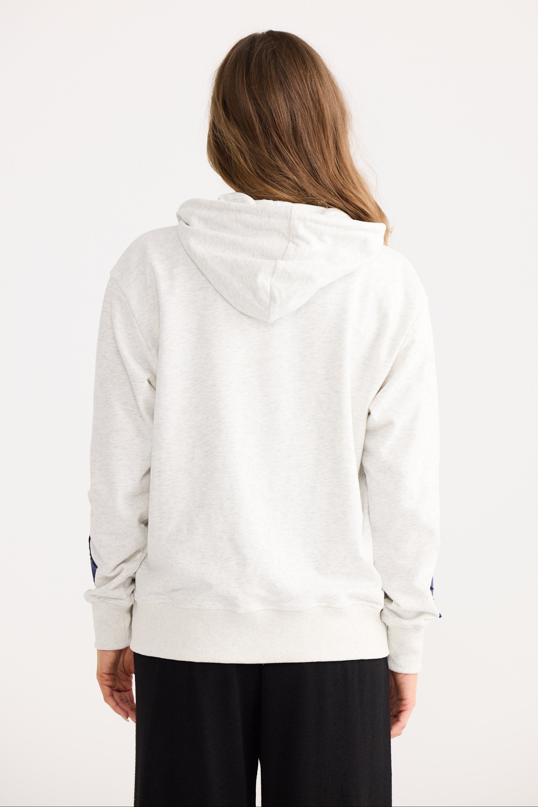Person wearing a light gray hoodie with a white background