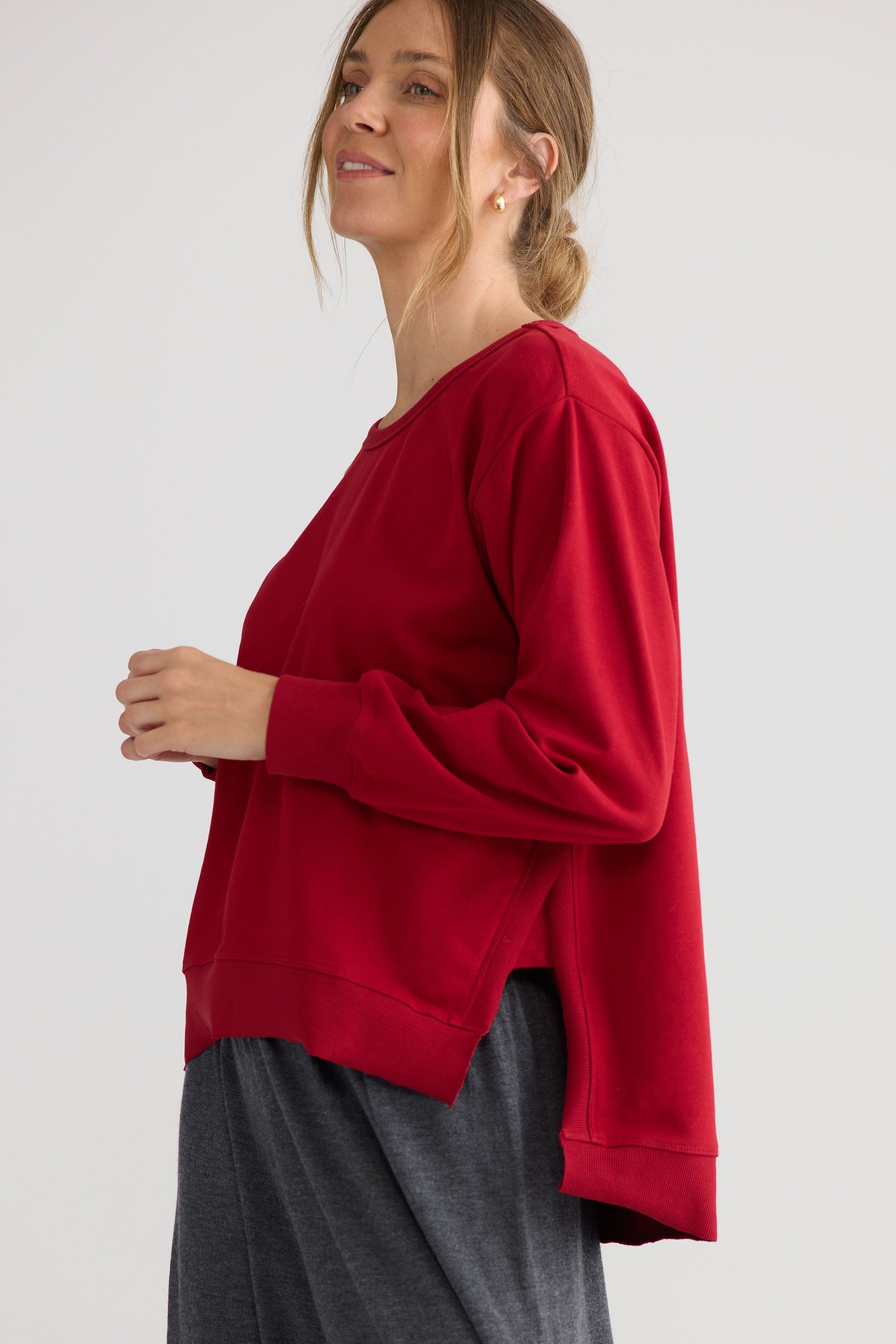 Model wearing Faye Lounge Jumper in scarlet, showing knit texture.