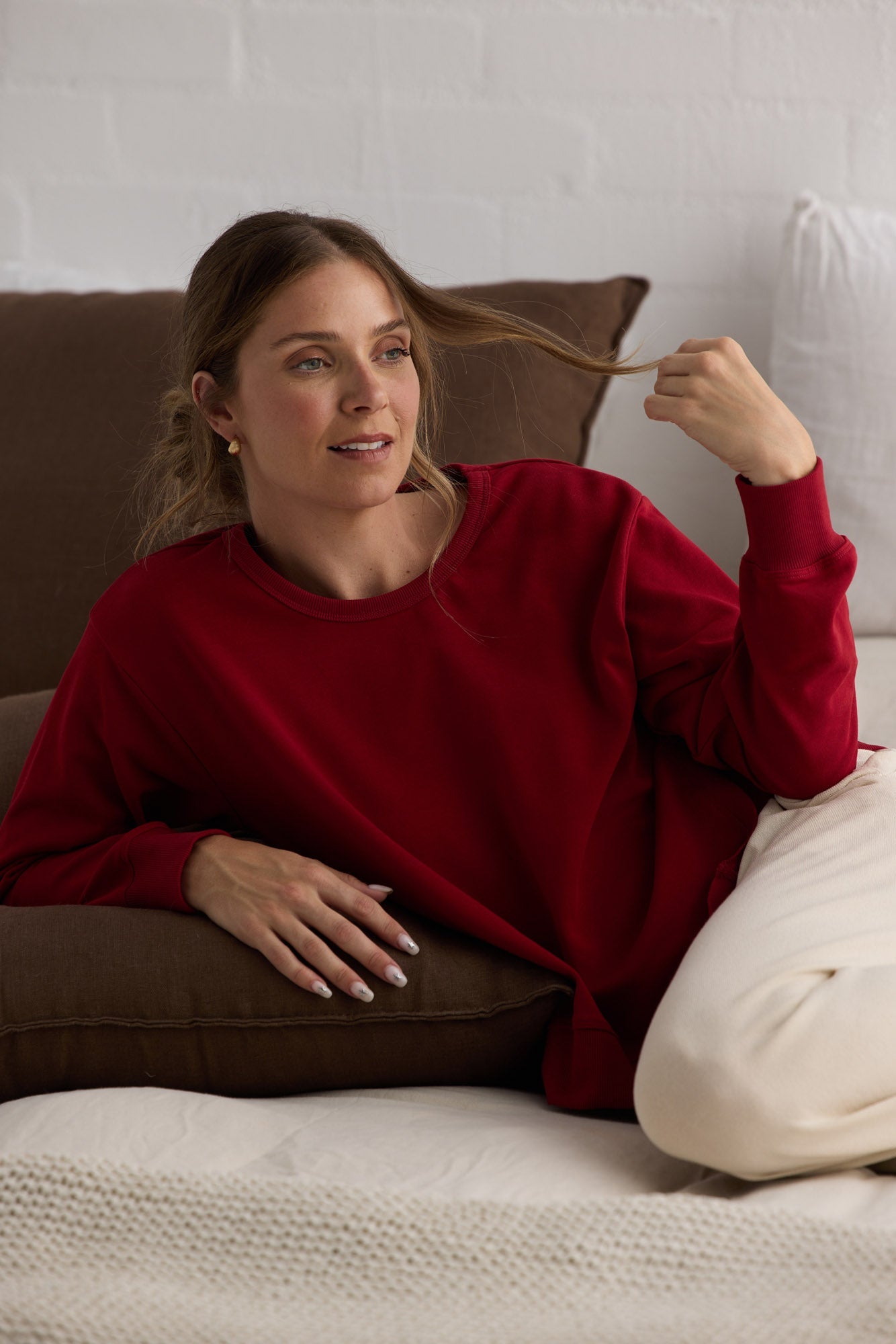 Campaign image of model wearing Faye Lounge Jumper in scarlet.