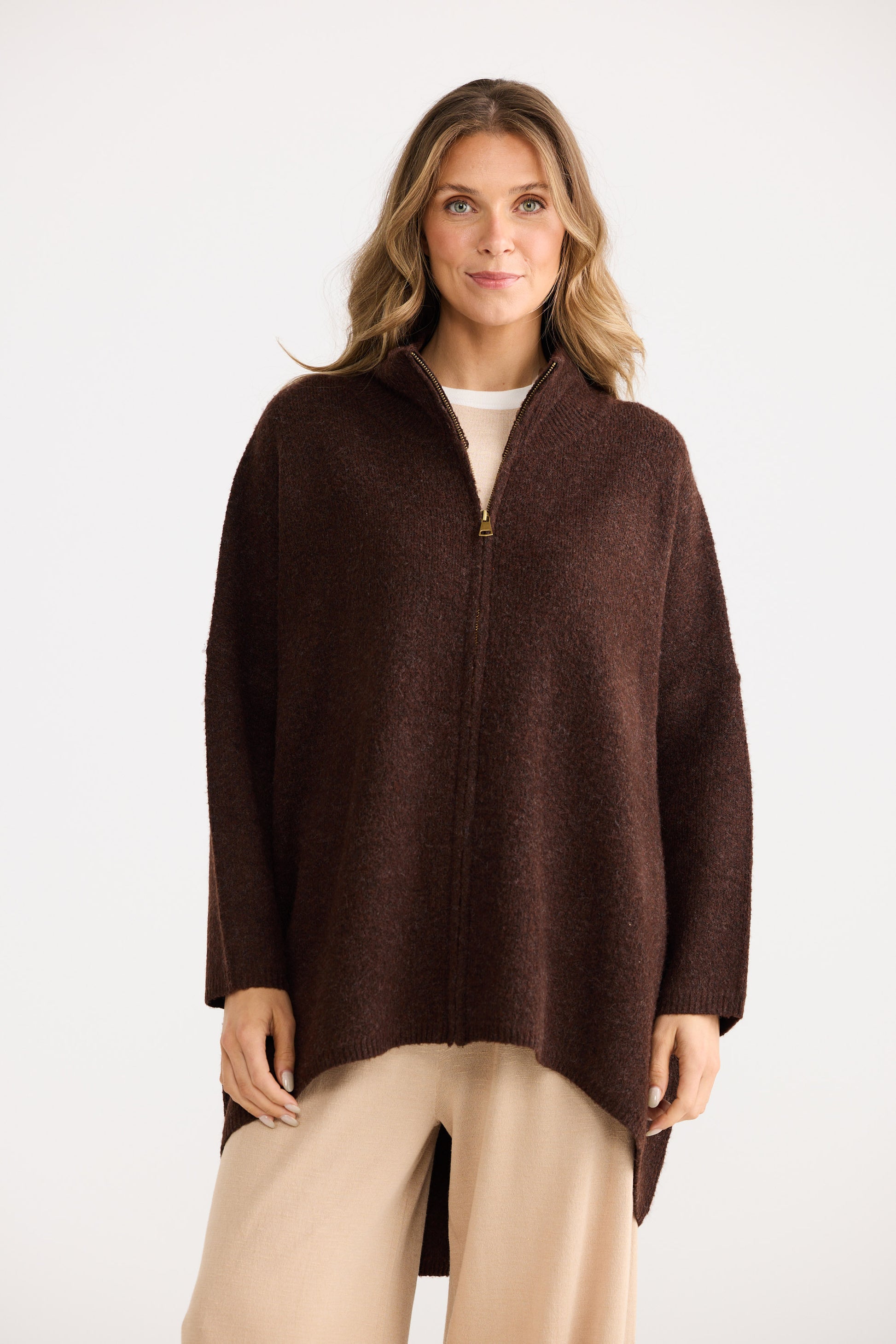 Woman wearing a brown poncho on a white background