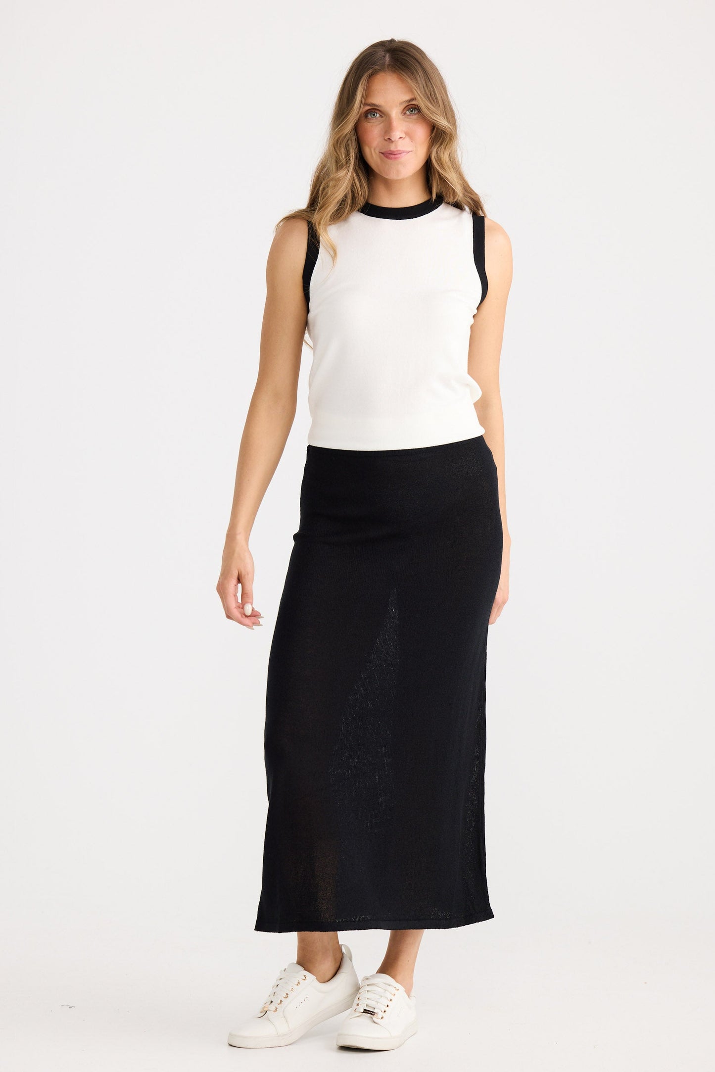 Woman wearing a white top and black skirt on a white background