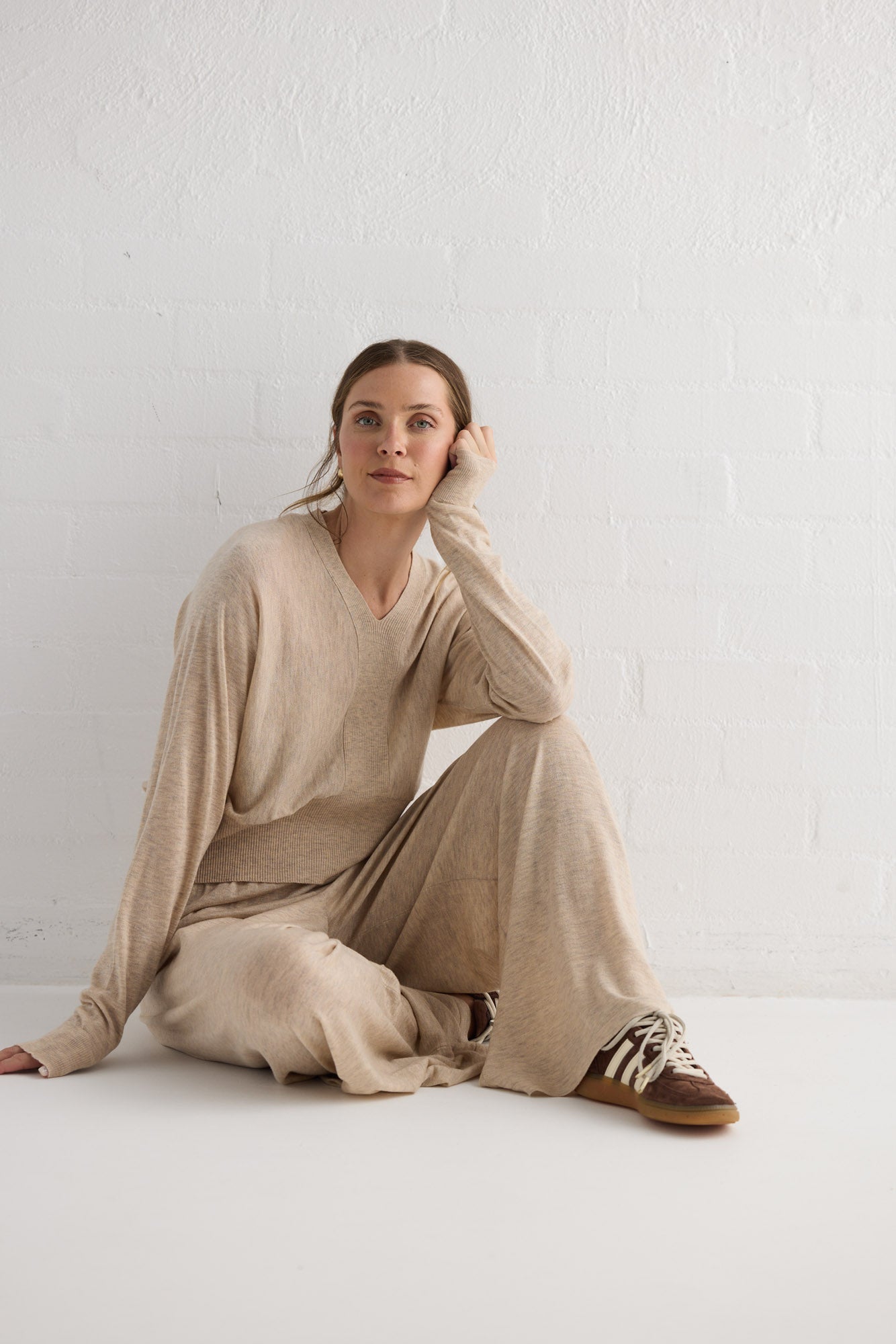 Campaign image of model wearing Stillness Knit Pant in oat.