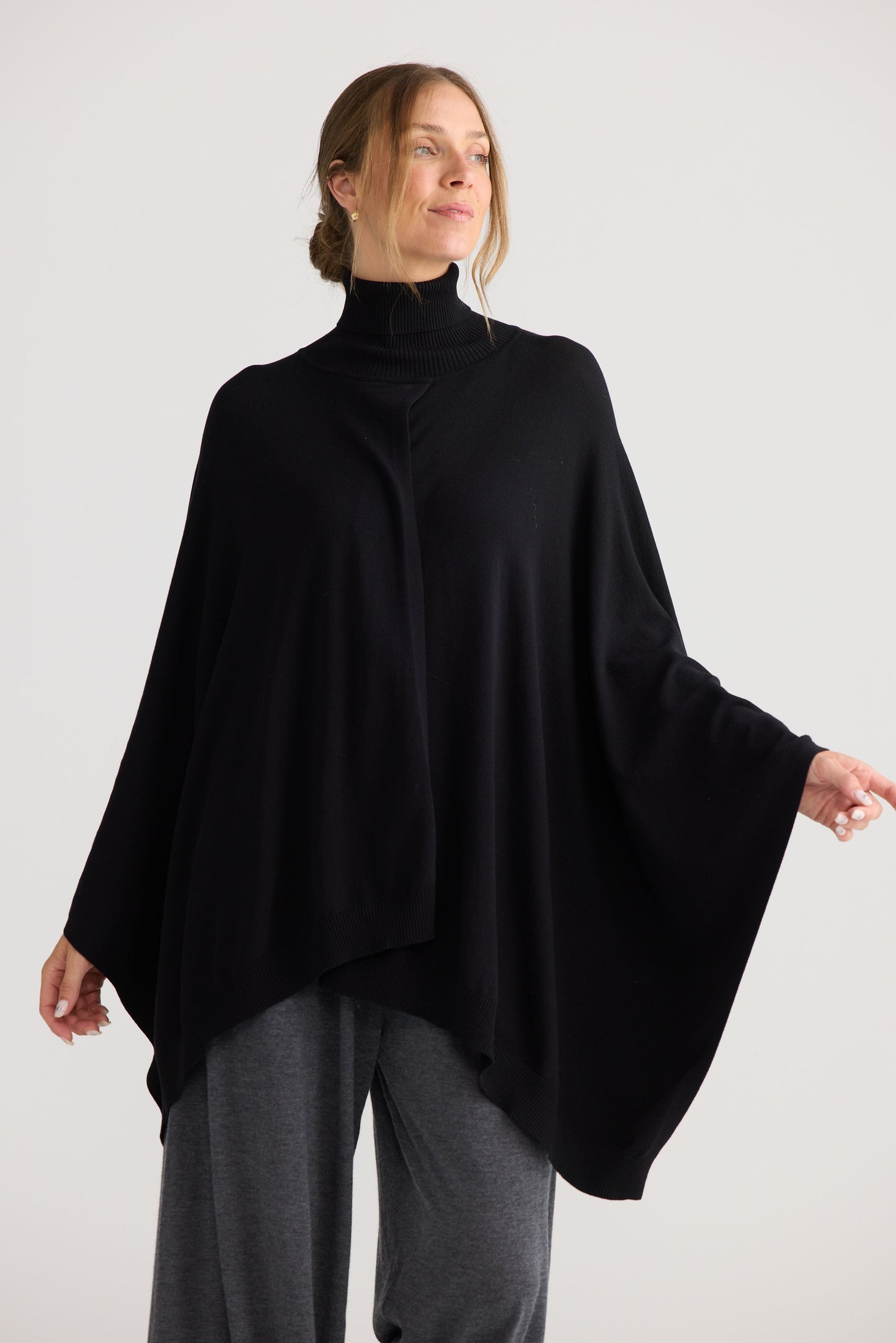 Awaken Knit Cape in black, showing draped cape shape.