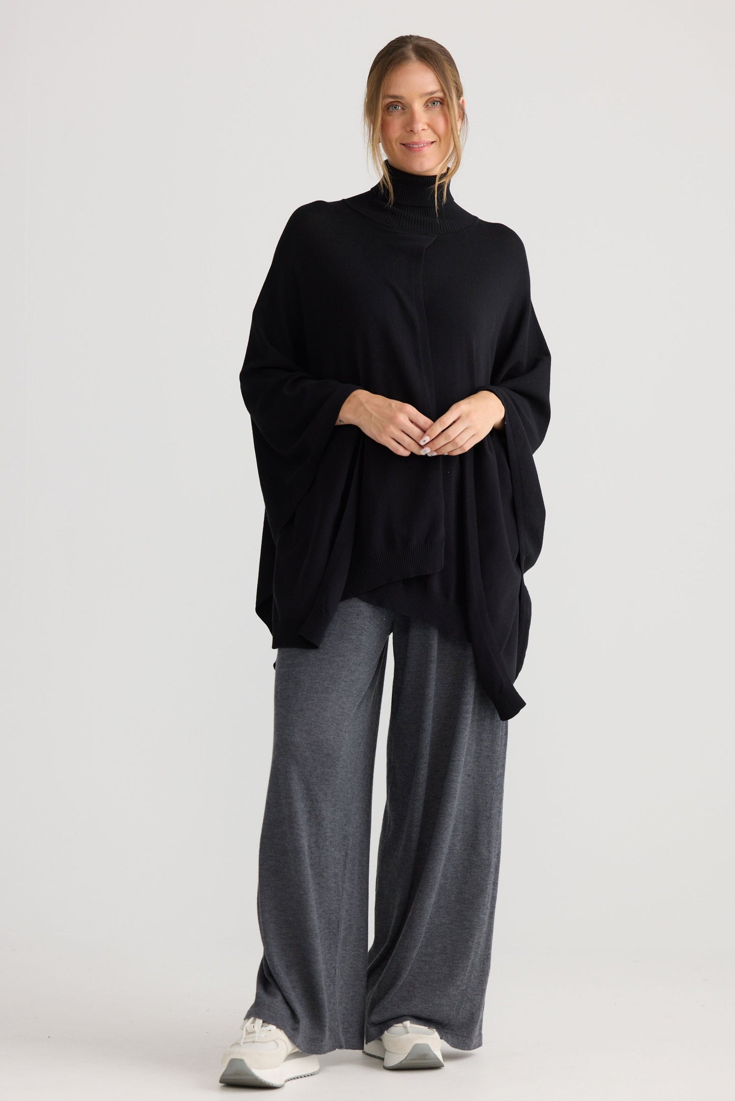 Model wearing Awaken Knit Cape in black.
