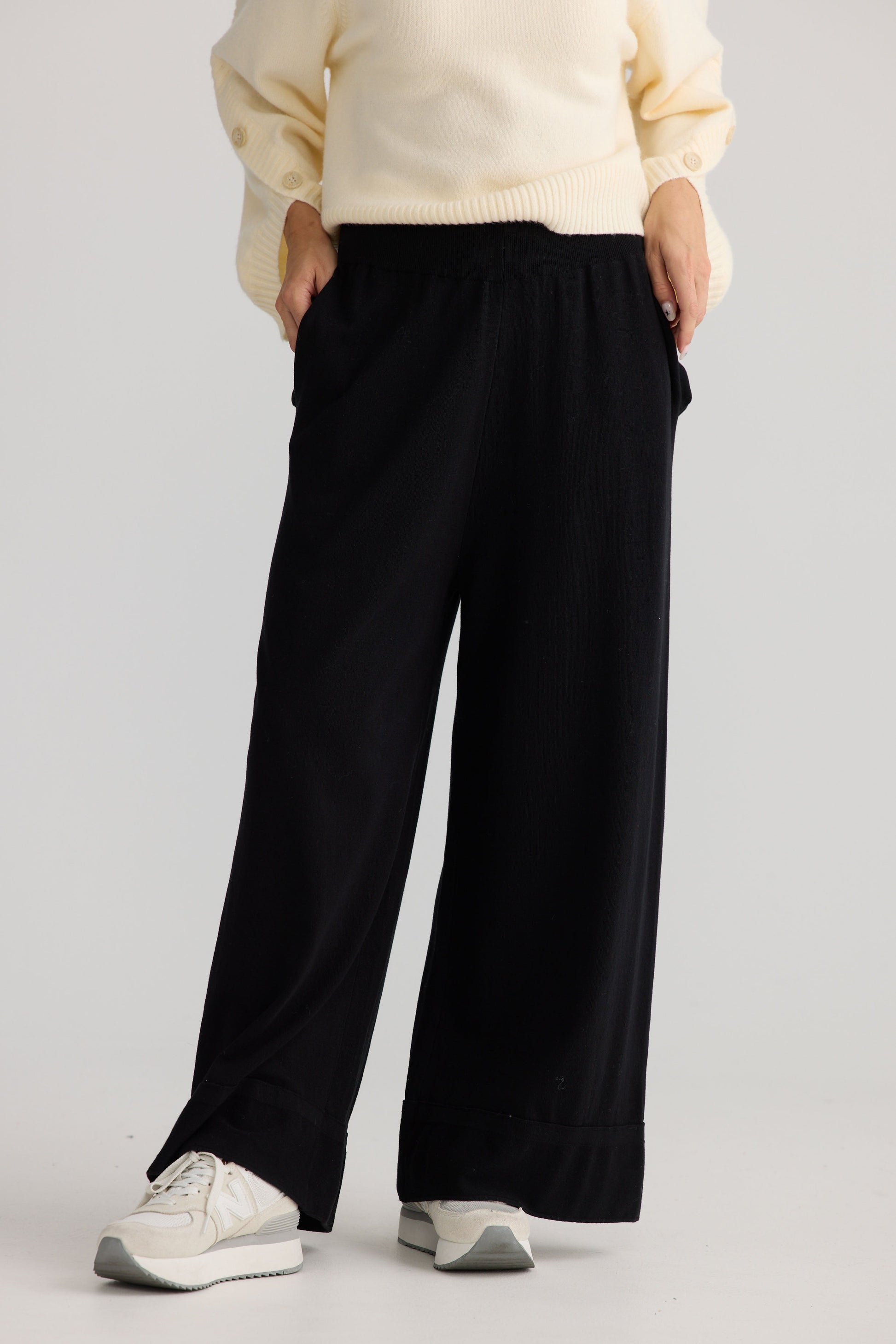 Model wearing Awaken Knit Pant in black, showing relaxed leg shape.