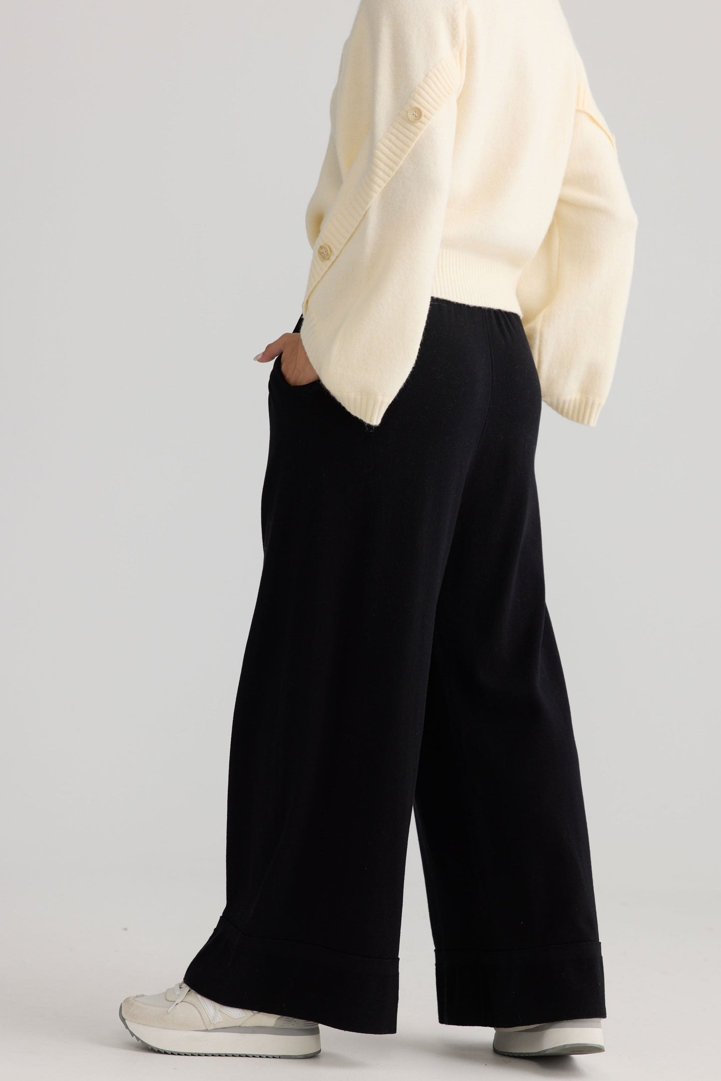 Model wearing Awaken Knit Pant in black, styled for everyday wear.
