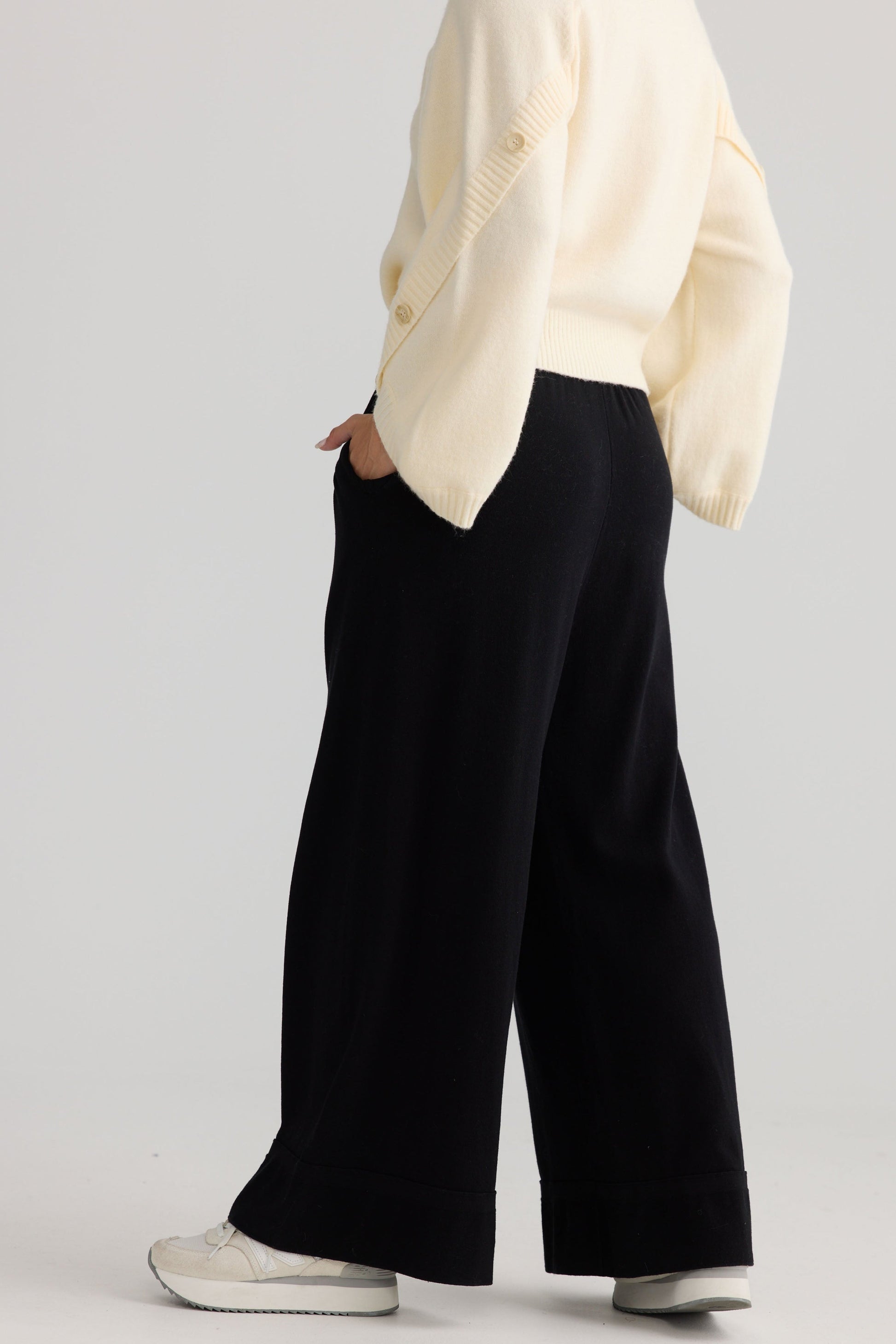 Model wearing Awaken Knit Pant in black, styled for everyday wear.