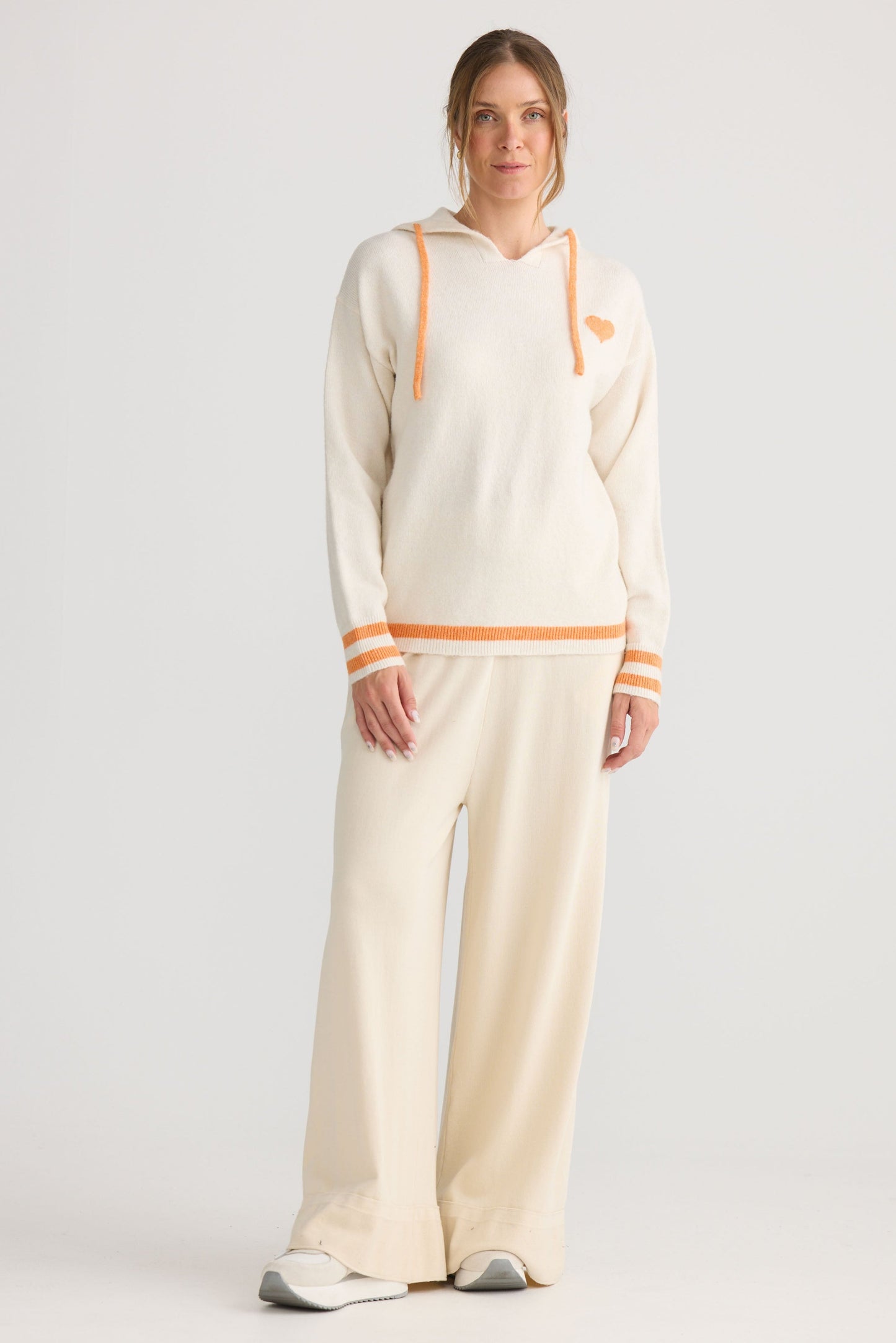 Model wearing Bold Hearts Hoodie in off white, styled for everyday wear.