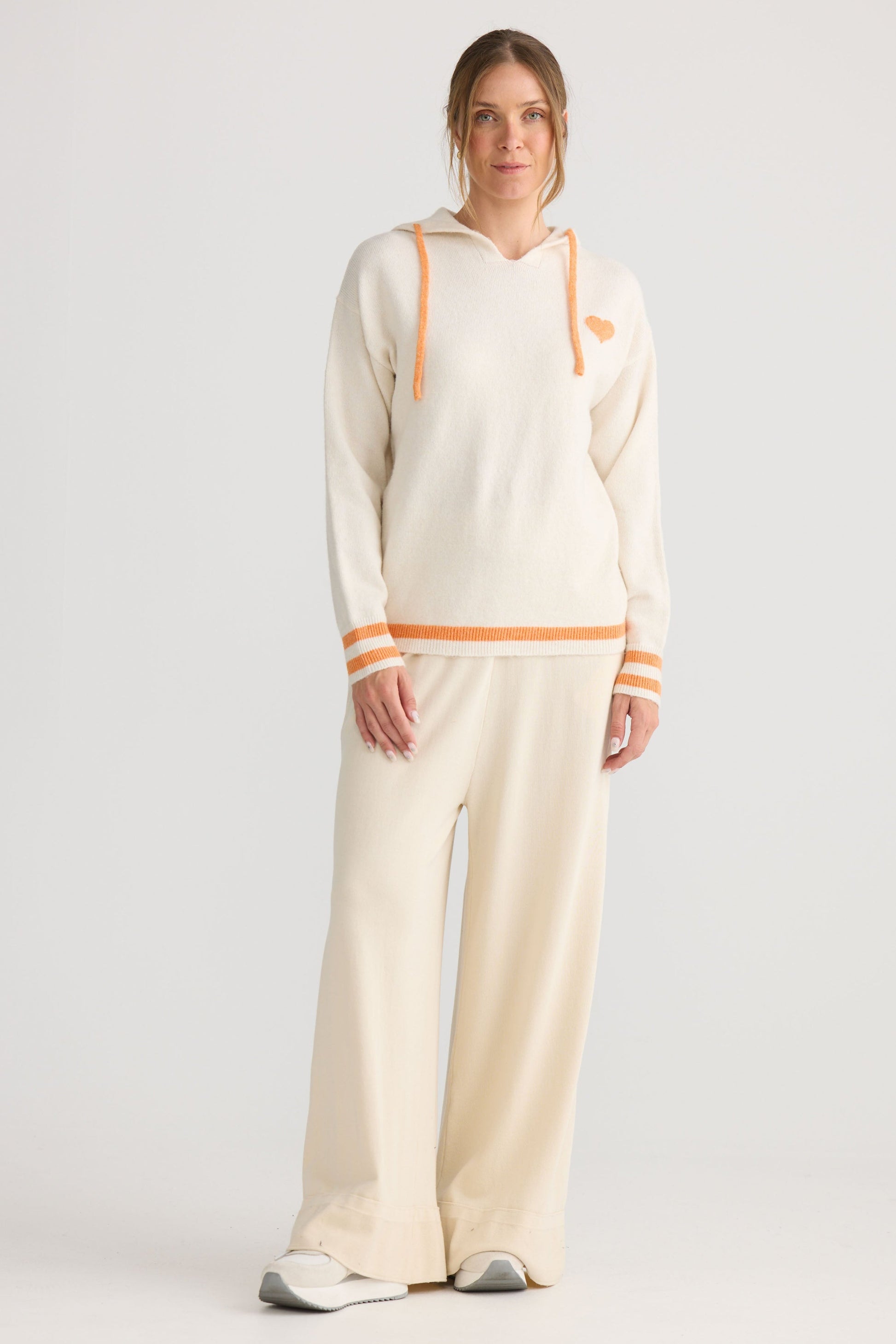 Model wearing Bold Hearts Hoodie in off white, styled for everyday wear.