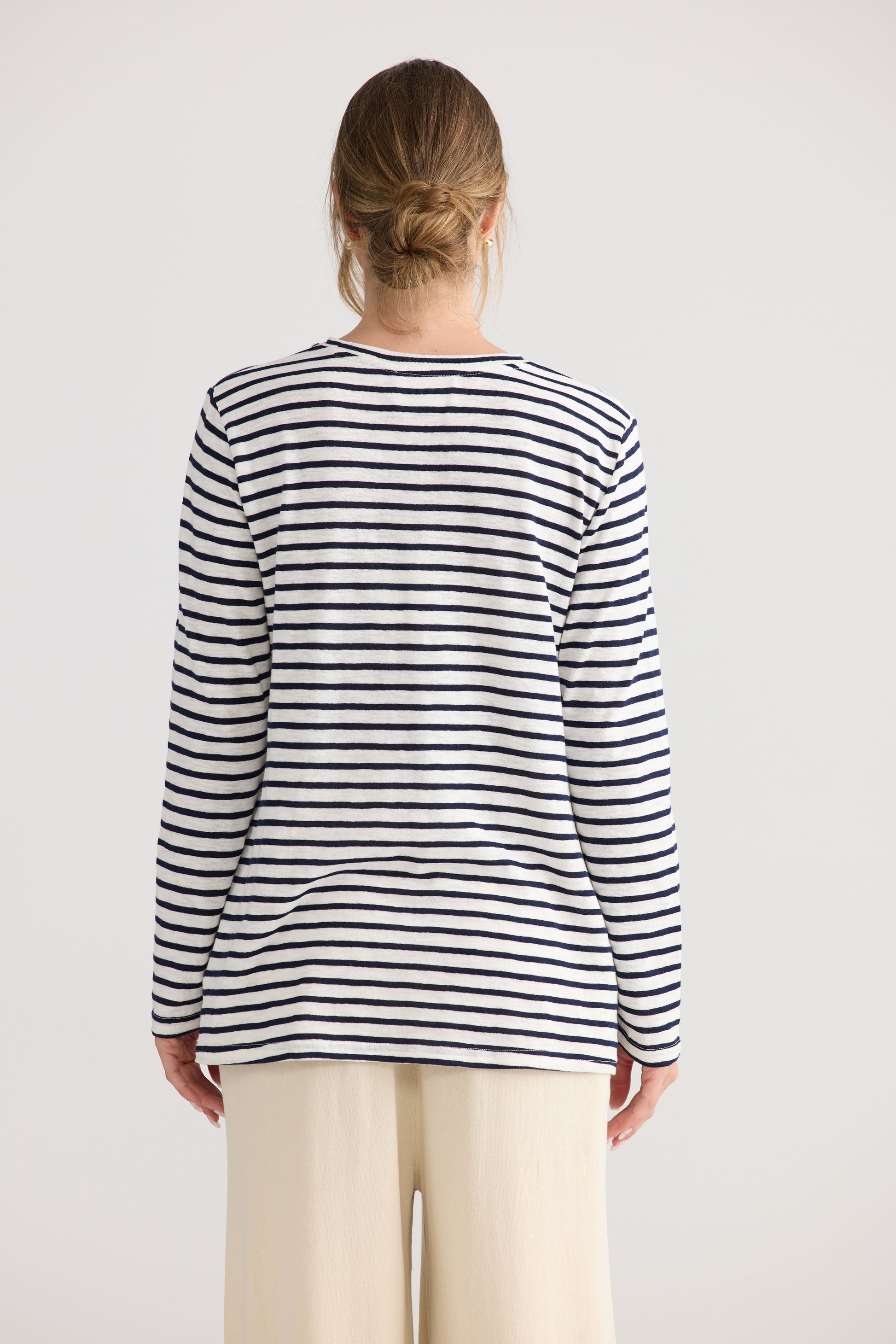 Model wearing Sana LS Top in navy stripe, styled for everyday wear.